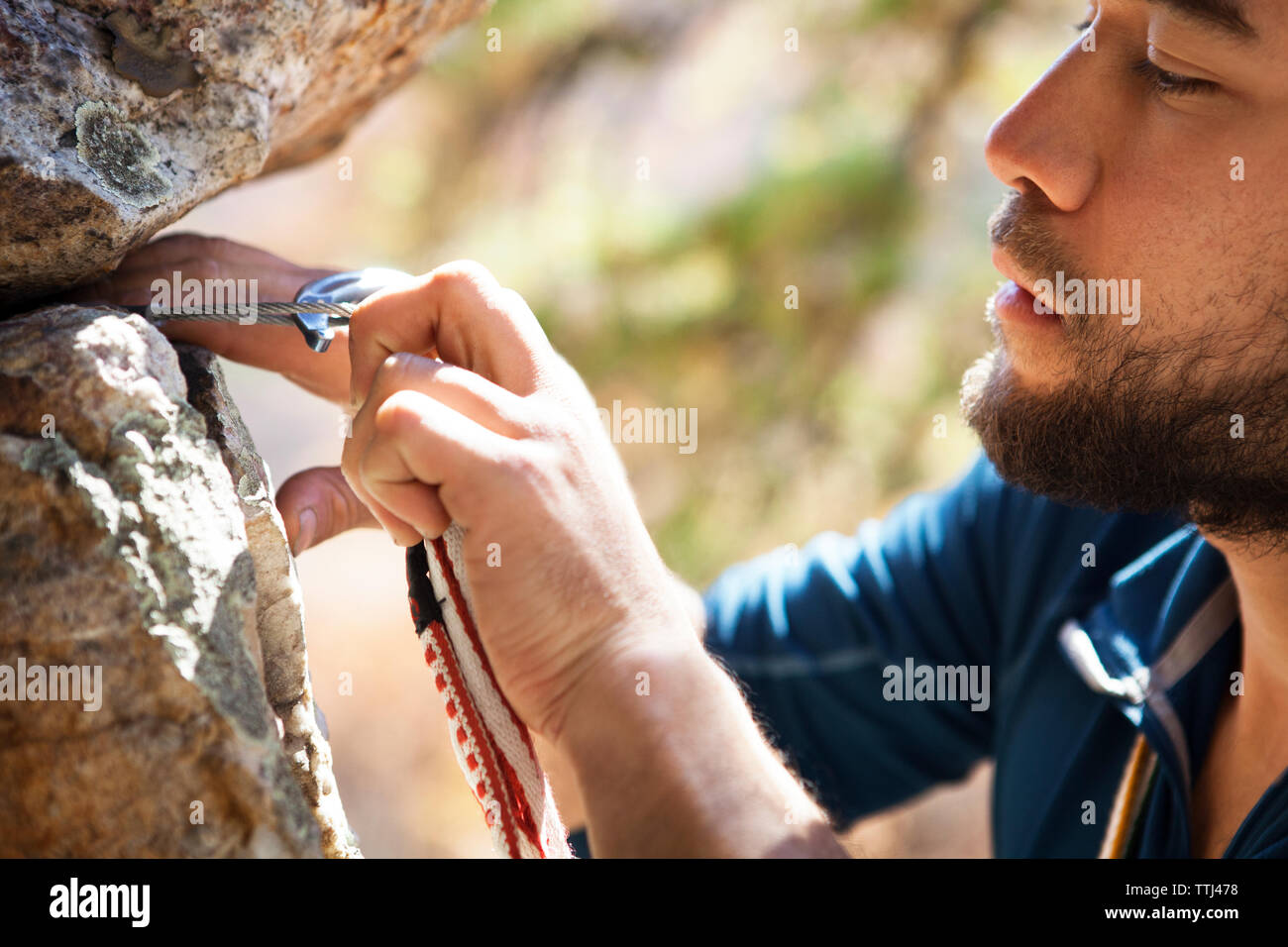 Immagine ritagliata di scalatore moschettone di fissaggio sulle rocce Foto Stock