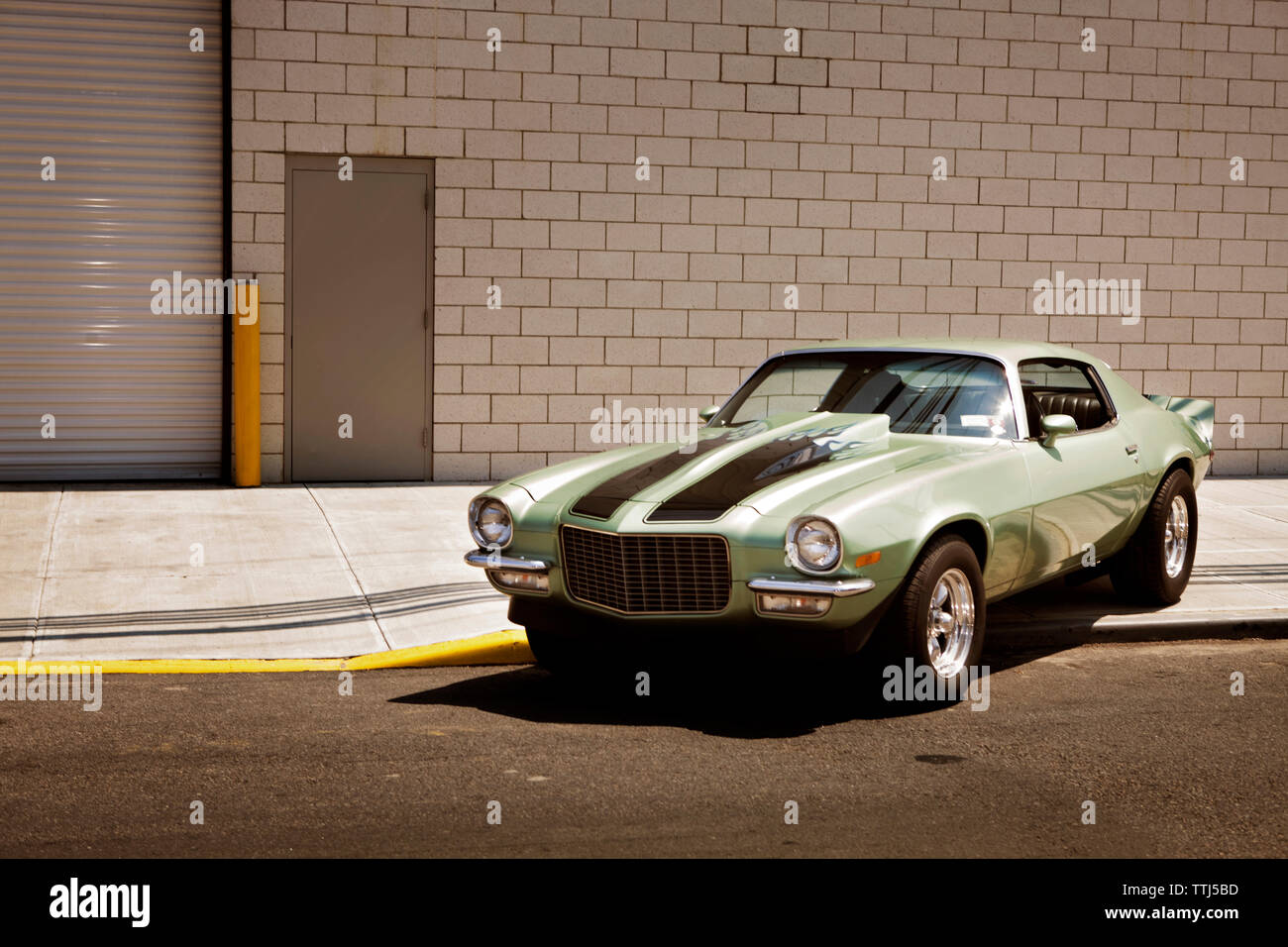 Verde auto sul sentiero contro l edificio in città Foto Stock