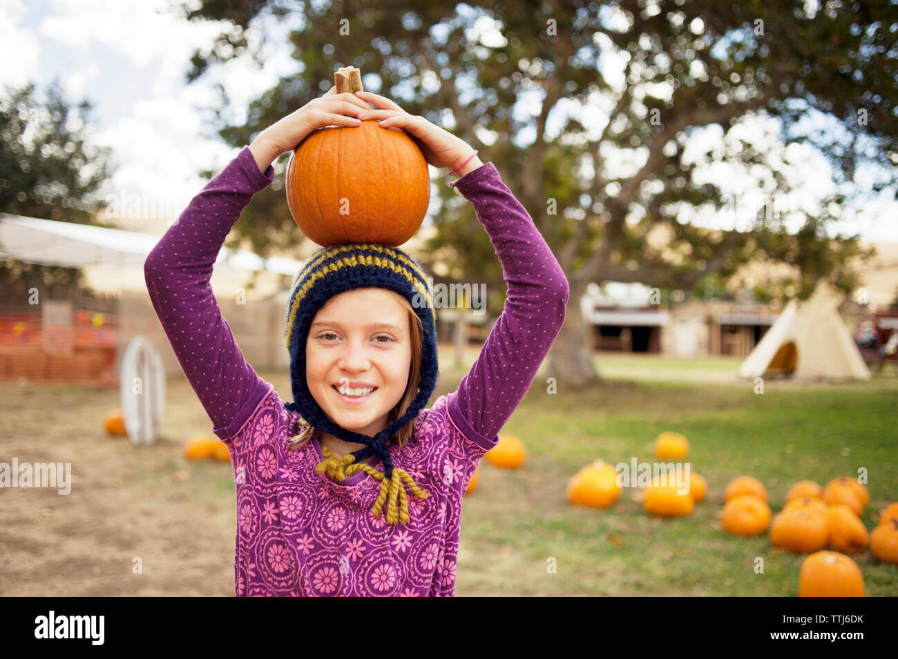 Ritratto di una ragazza che porta la zucca sulla testa in fattoria Foto Stock
