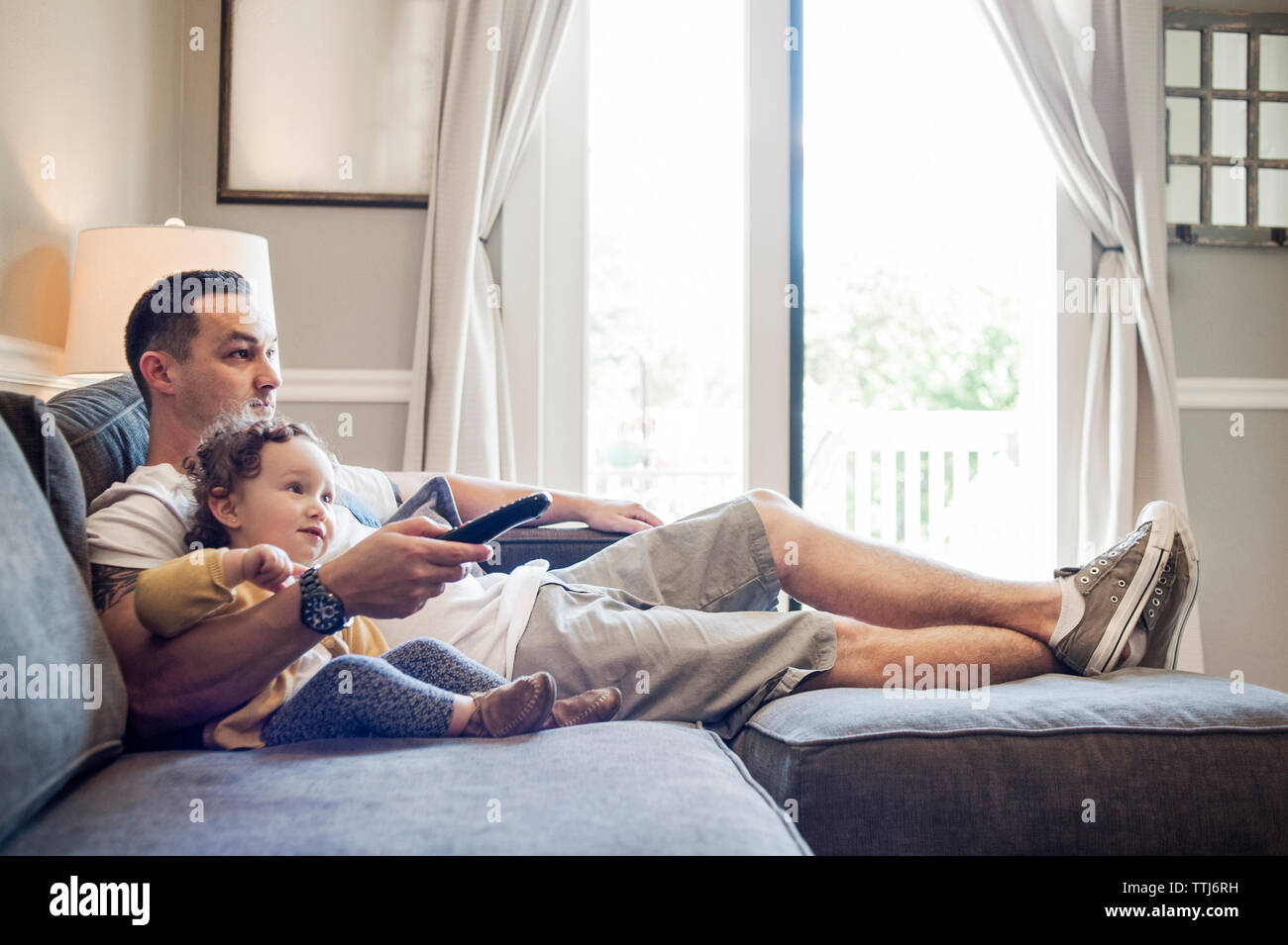 Padre e figlia di guardare la televisione a casa Foto Stock