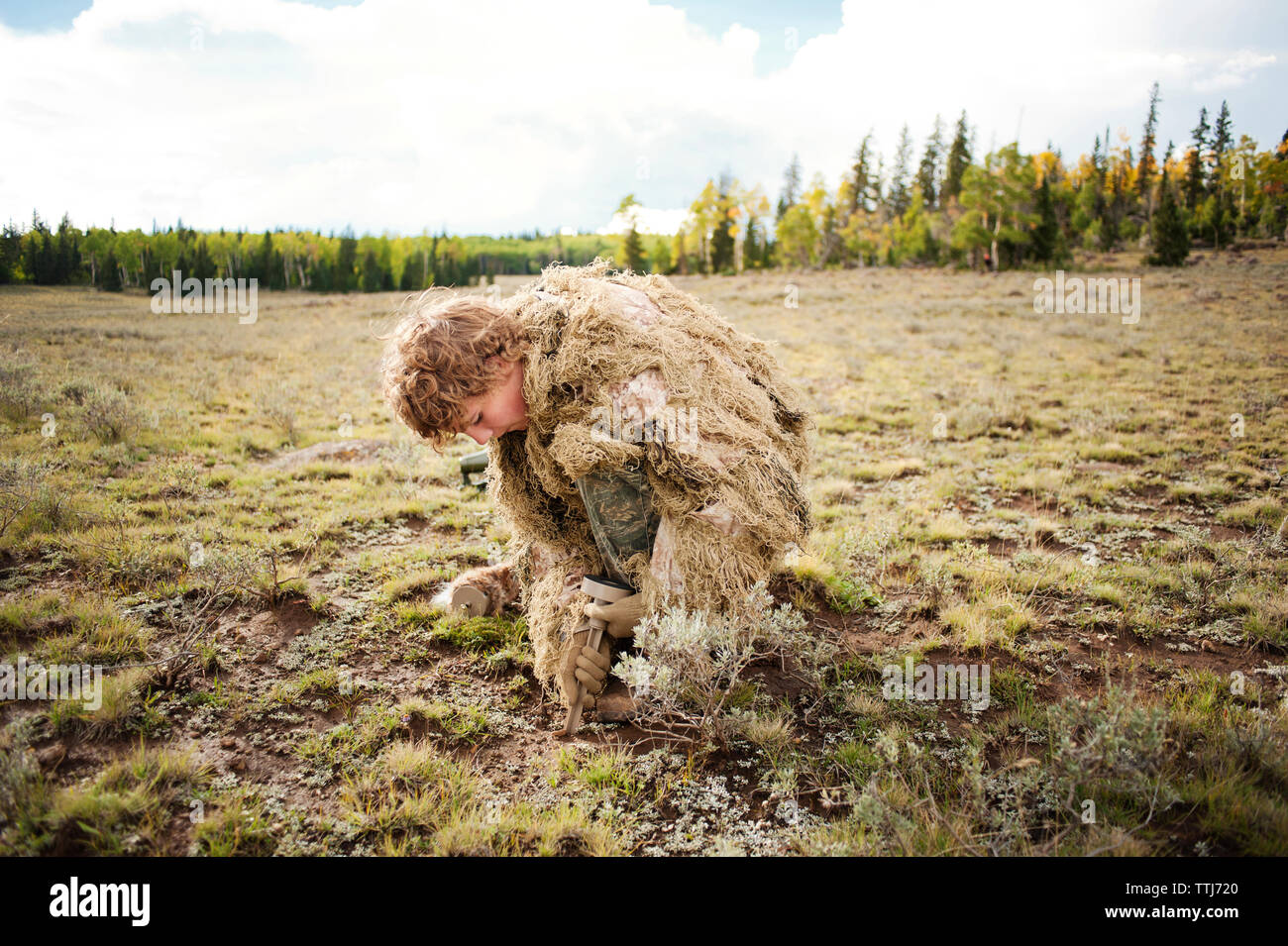Uomo in Abbigliamento camouflage scavare su campo Foto Stock