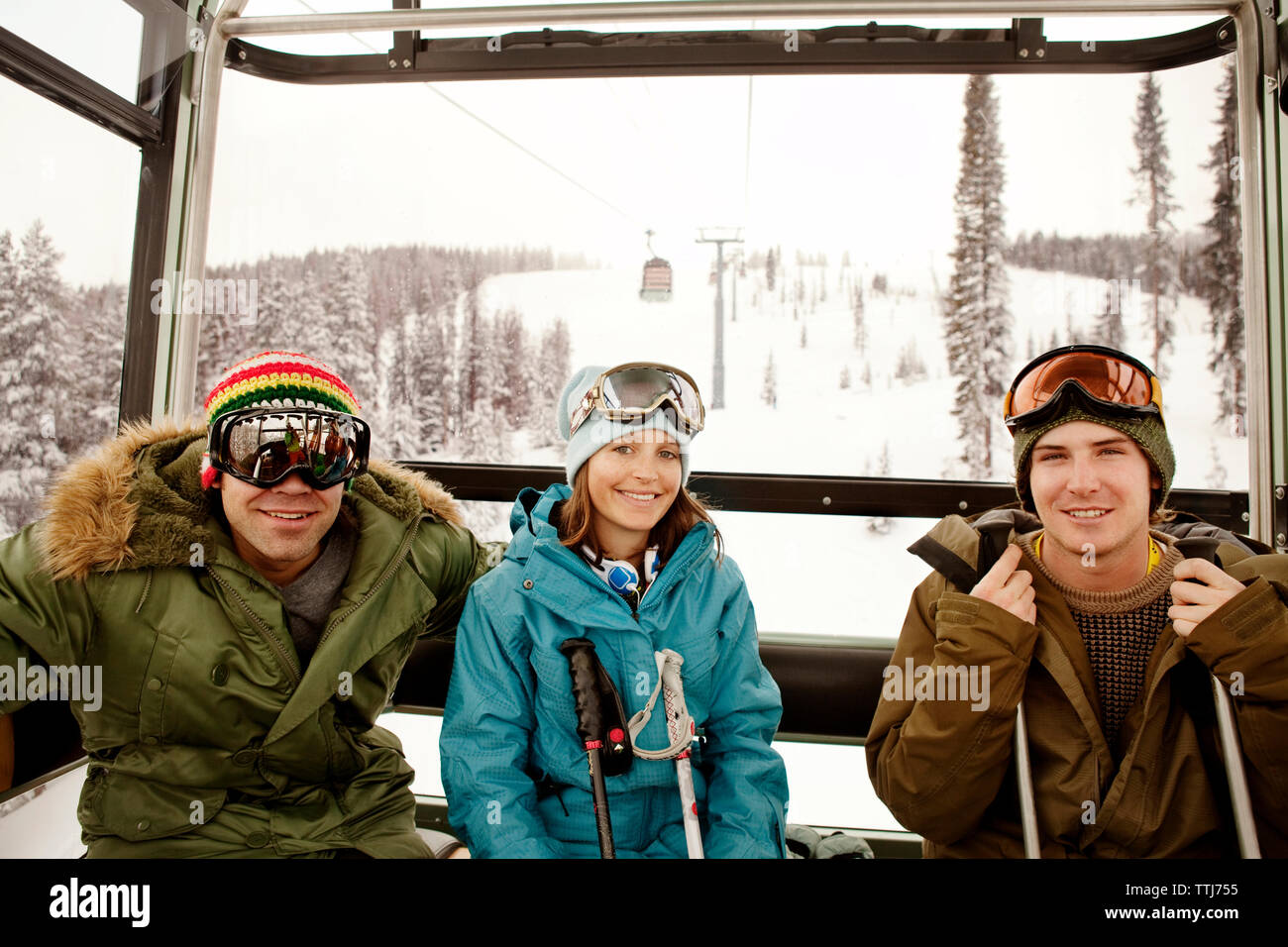 Ritratto di felice gli sciatori seduti in overhead funivia Foto Stock