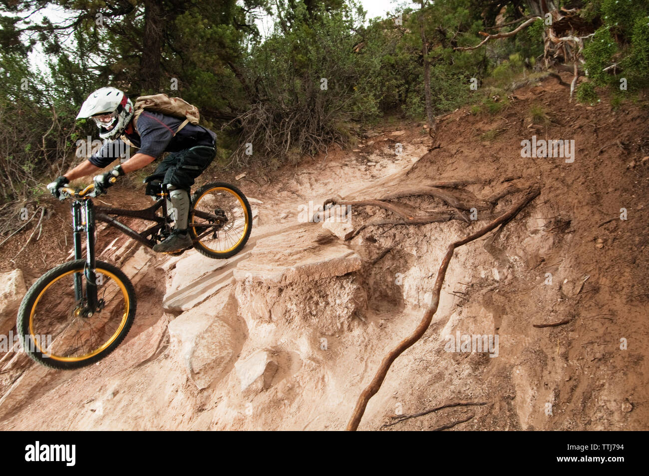Atleta maschio escursioni in bicicletta sulle rocce Foto Stock
