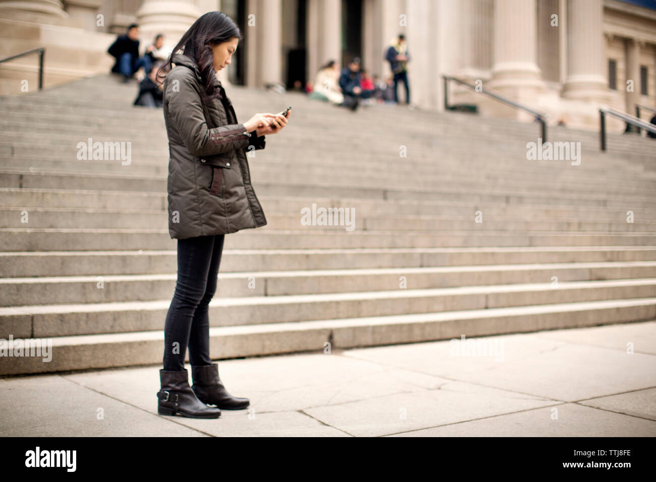 Donna che utilizza il cellulare mentre permanente al sentiero Foto Stock