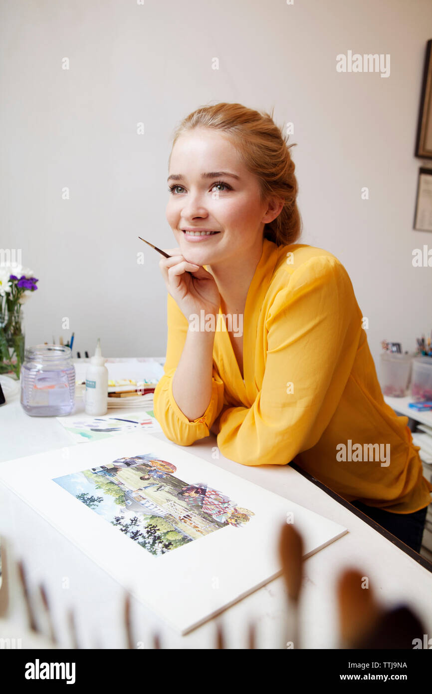 Donna che guarda lontano mentre si sta in piedi in studio Foto Stock