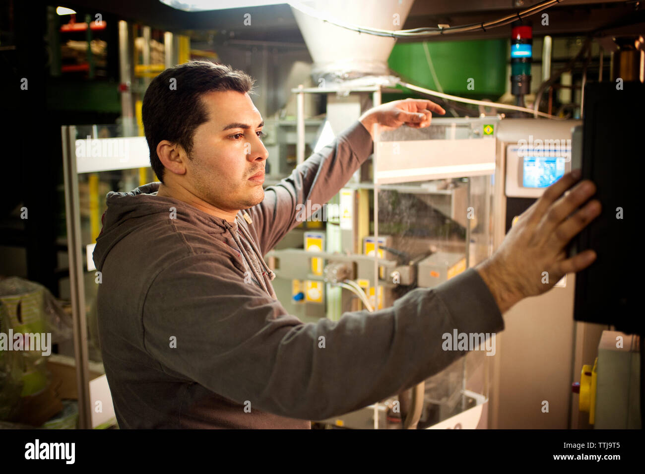 L'uomo esaminando i macchinari al caffè industria manifatturiera Foto Stock