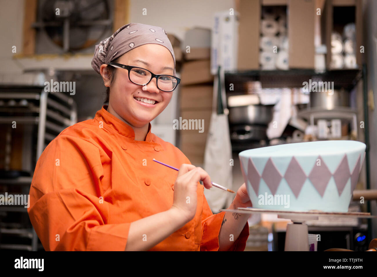 Ritratto di donna la decorazione torta al negozio Foto Stock