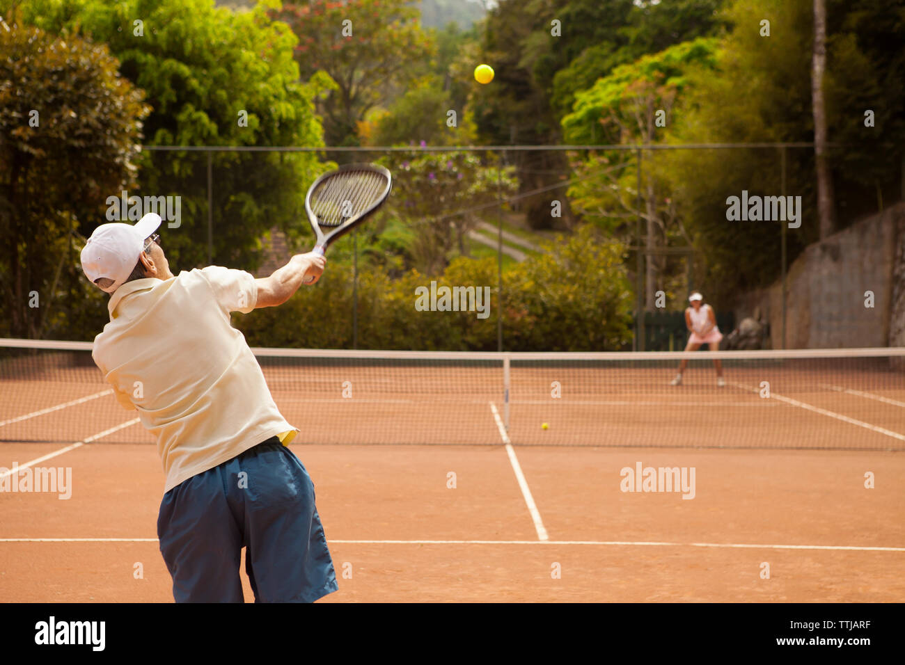 Coppia senior giocando a tennis a corte Foto Stock