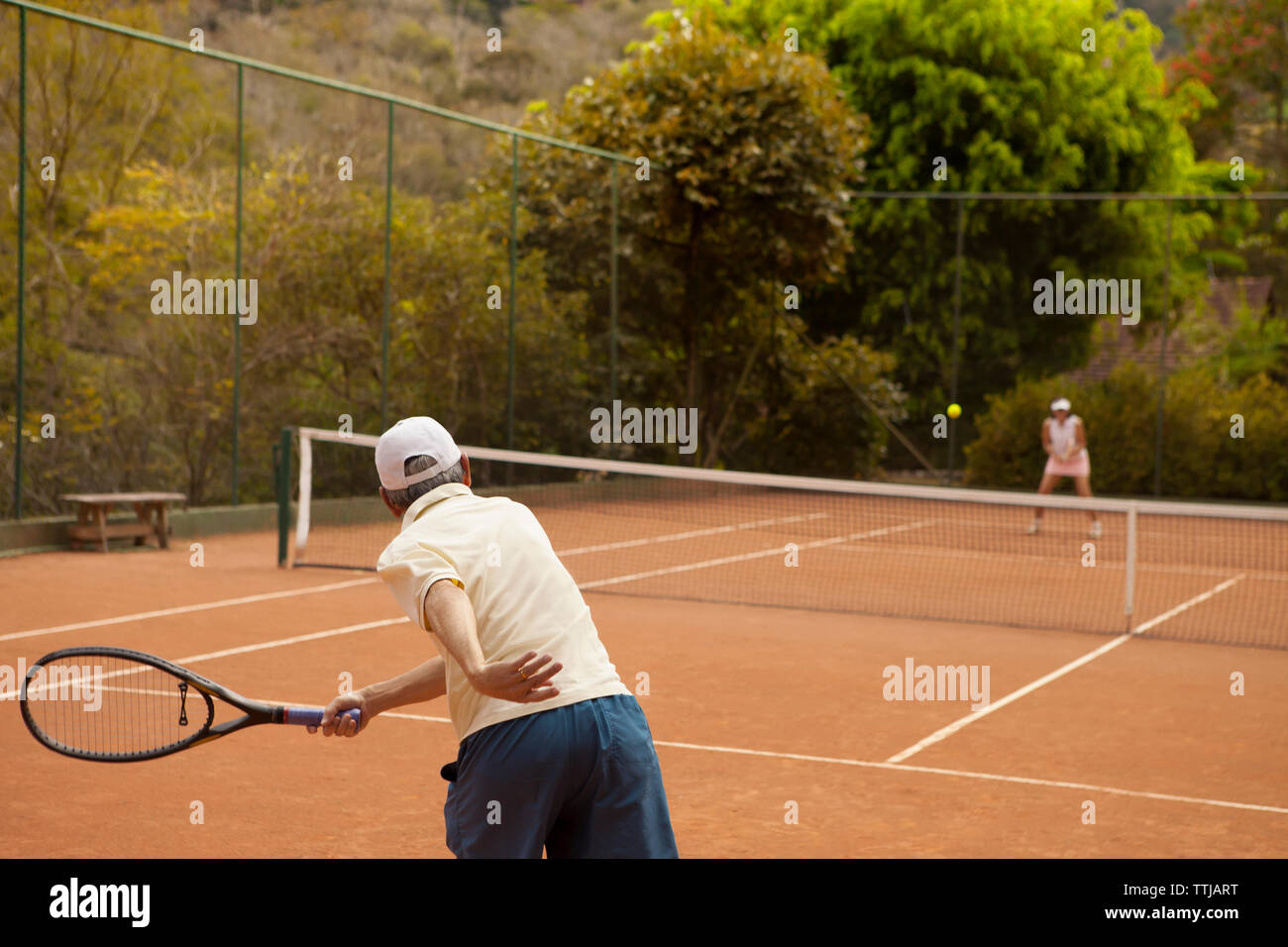Coppia senior godendo di tennis alla corte Foto Stock
