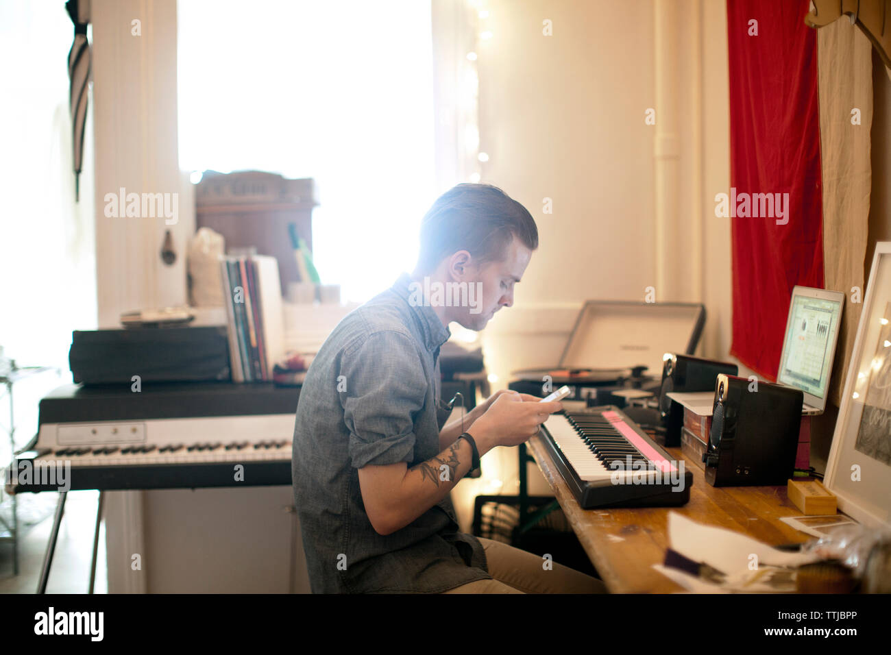 Uomo che utilizza il telefono cellulare a casa Foto Stock