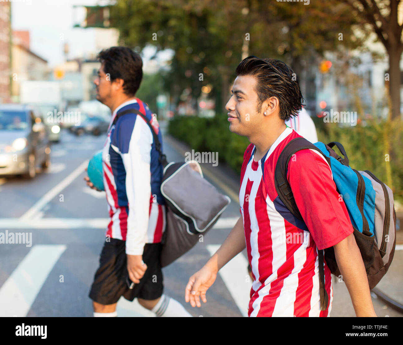 I giocatori di calcio di strada di attraversamento di strada di città Foto Stock