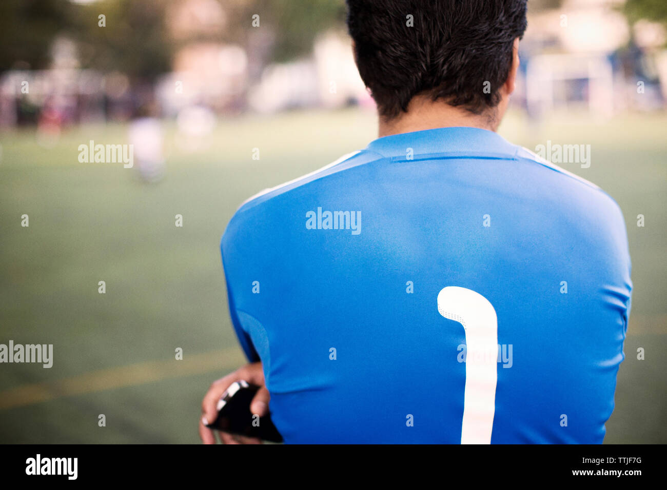 Vista posteriore del giocatore di calcio permanente al campo Foto Stock