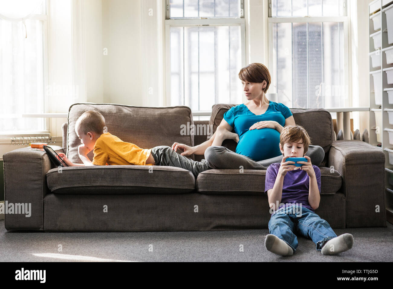 Donna incinta con i bambini a casa Foto Stock