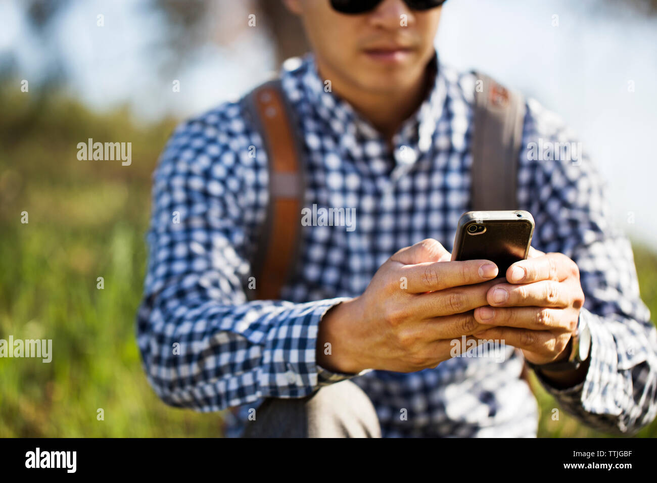 Sezione mediana dell'uomo utilizzando il telefono cellulare Foto Stock