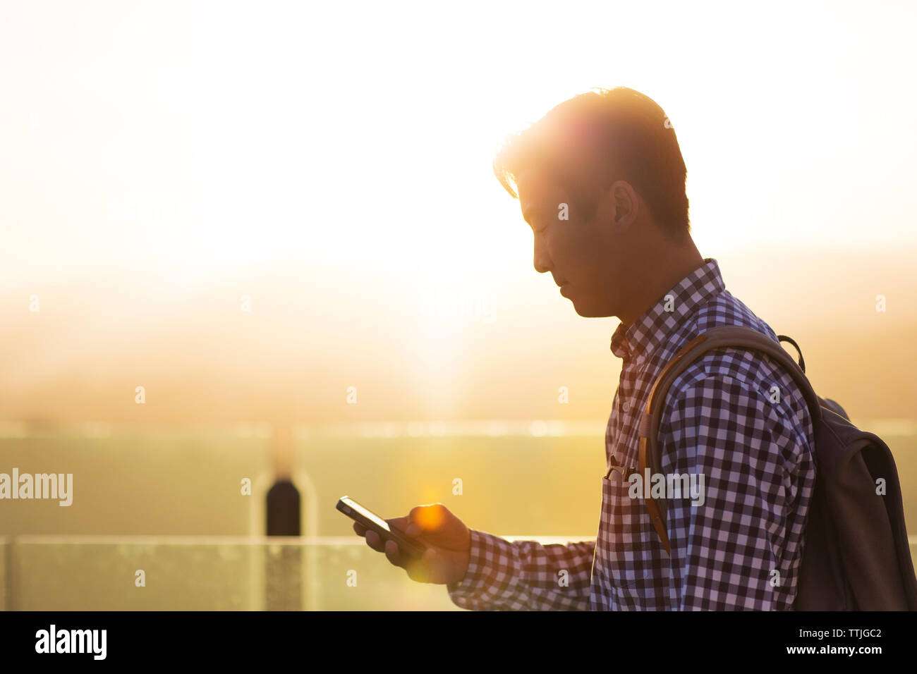 Vista laterale dell'uomo utilizzando il telefono cellulare Foto Stock