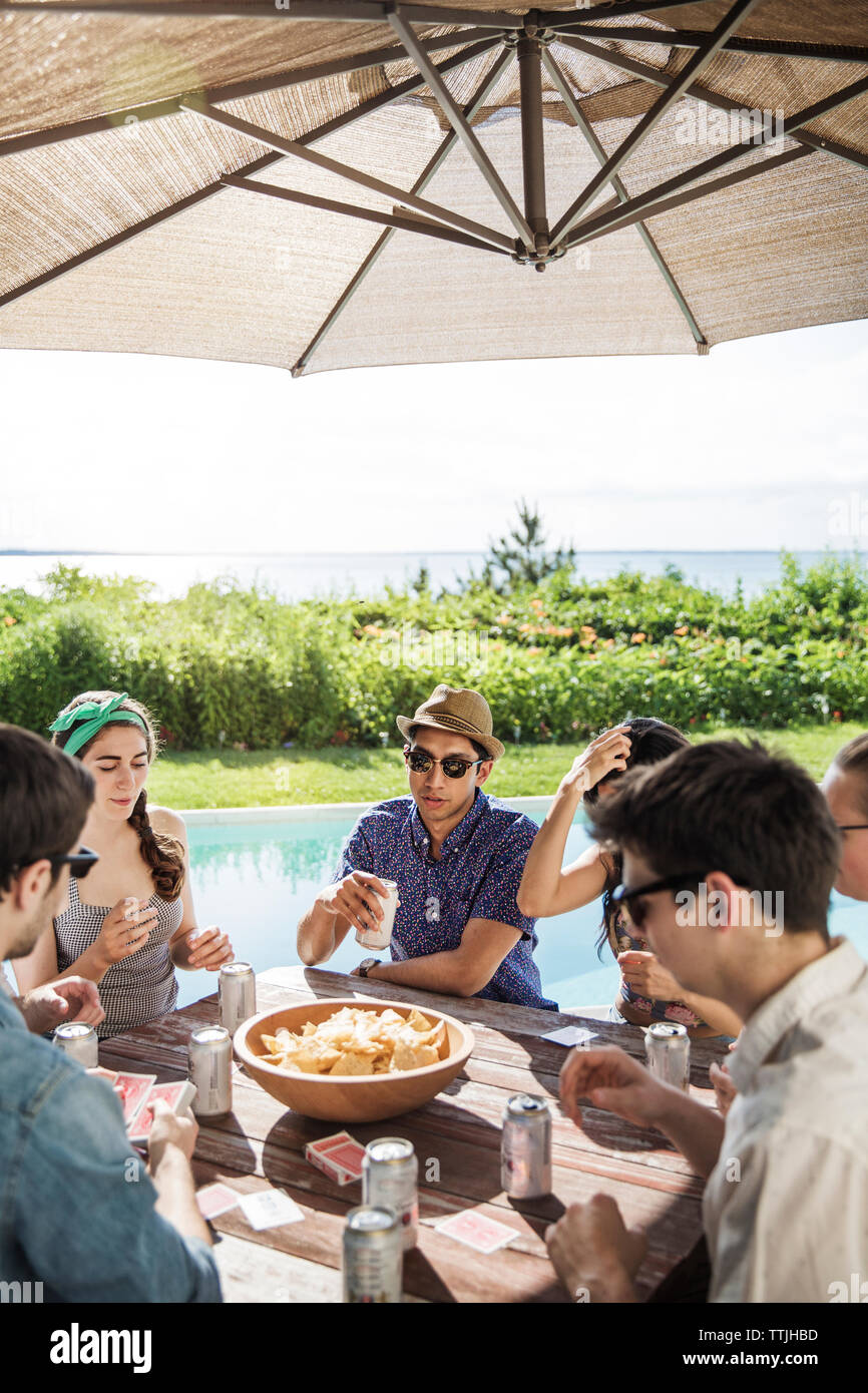 Happy amici giocare gioco di carte in cortile Foto Stock