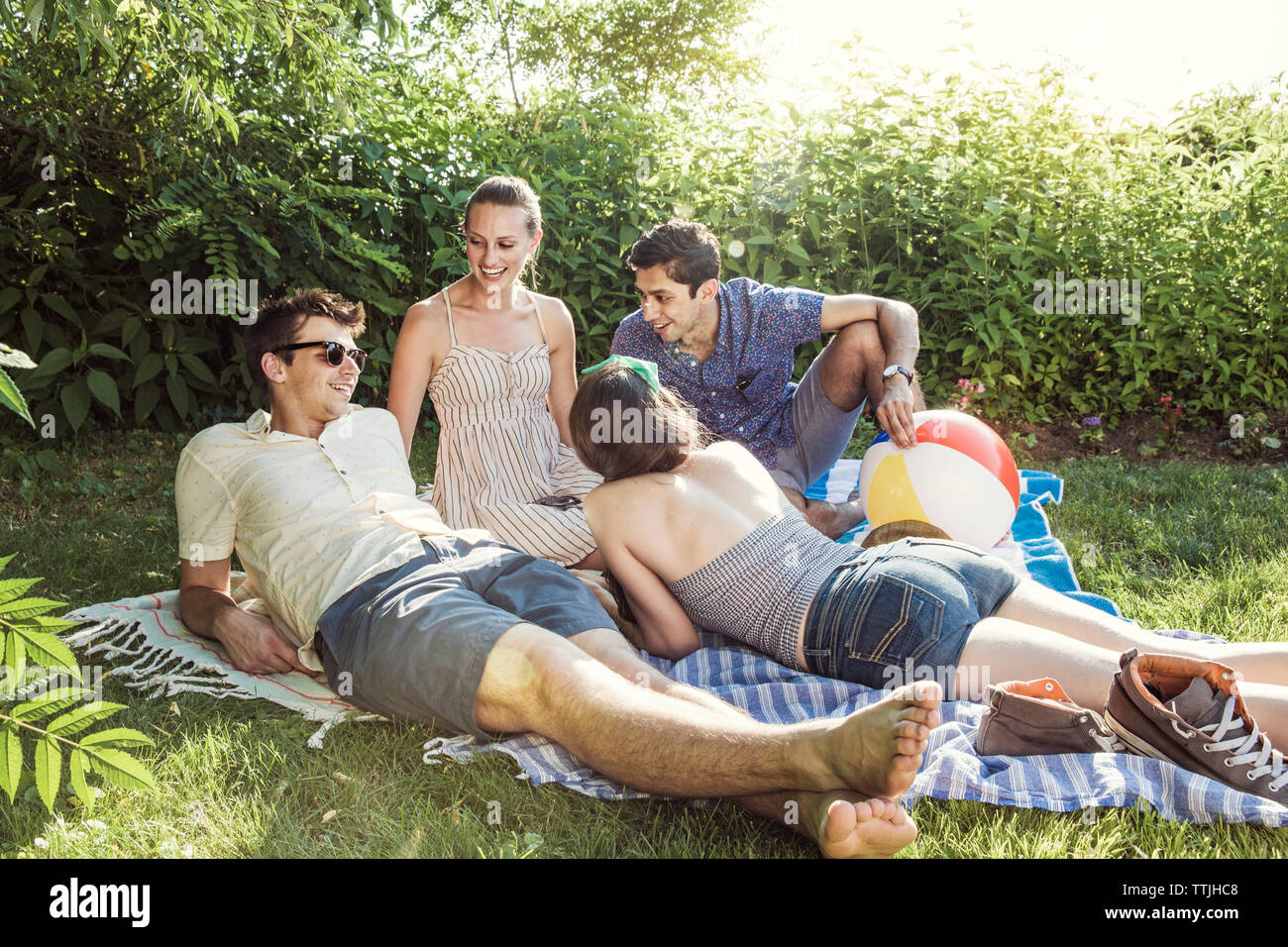 Happy amici parlano in cortile sulla giornata di sole Foto Stock