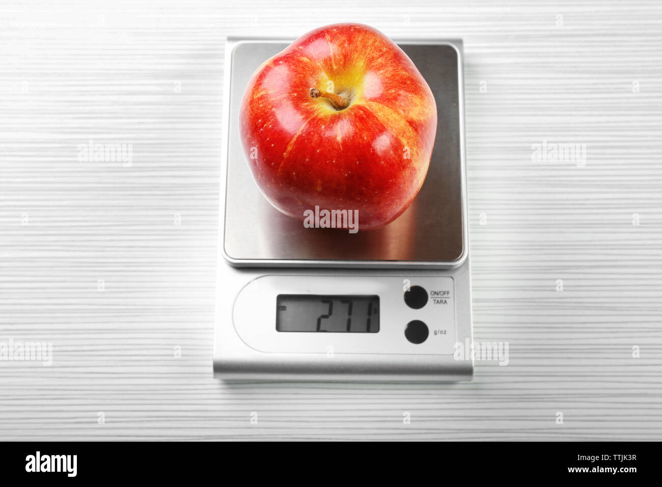 Apple con digital bilancia da cucina su sfondo di legno Foto stock - Alamy