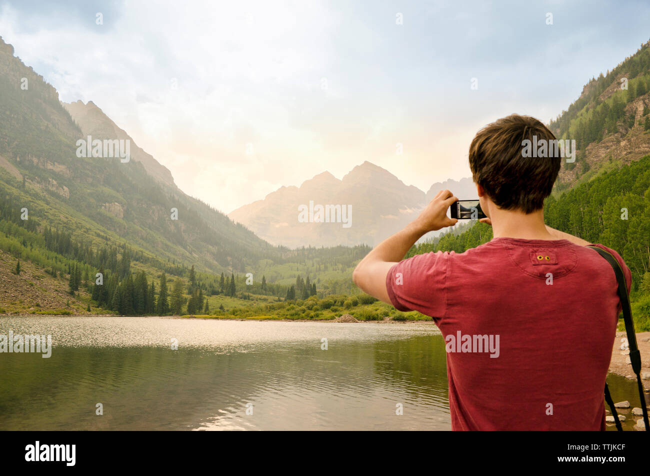 Vista posteriore dell'uomo a fotografare le montagne Foto Stock