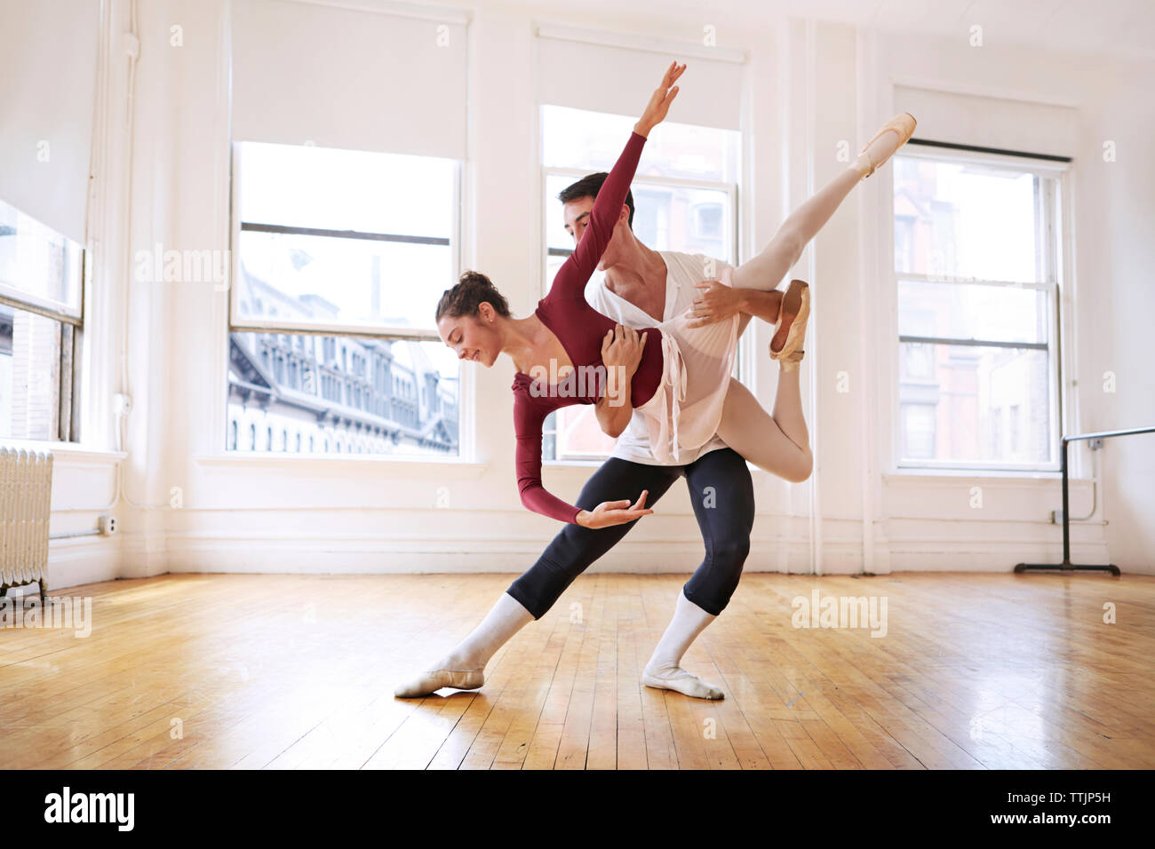 Lunghezza completa di grazioso maschio e femmina di ballerini eseguono in studio Foto Stock
