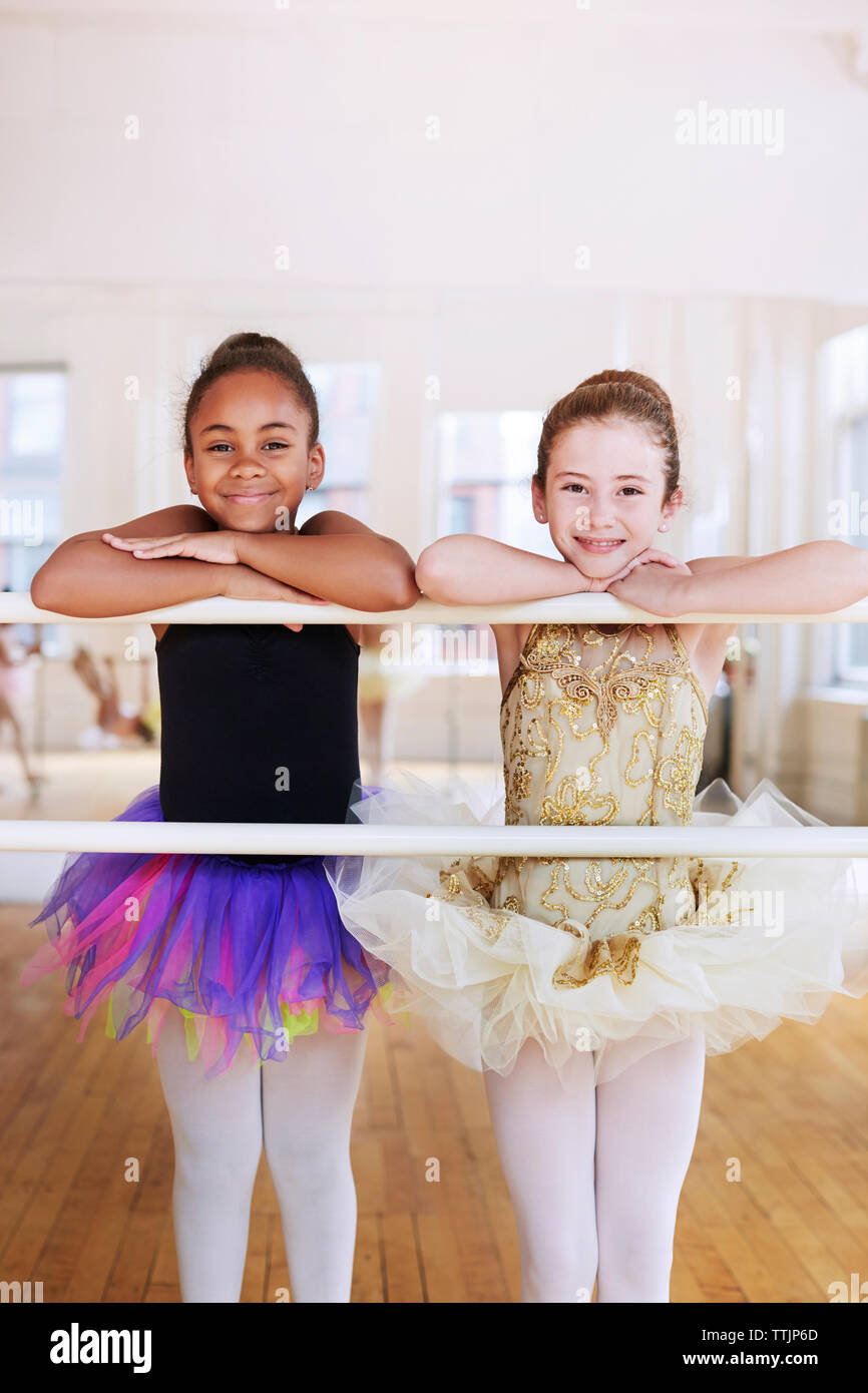 Ritratto di sorridere ballerine poggiando su asta in studio Foto Stock