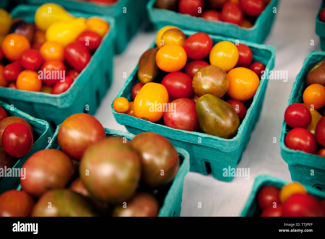 Angolo di alta vista di pomodori in contenitori di blu per la vendita al mercato Foto Stock Angolo di alta vista di pomodori in contenitori di blu per la vendita al mercato Foto Stock