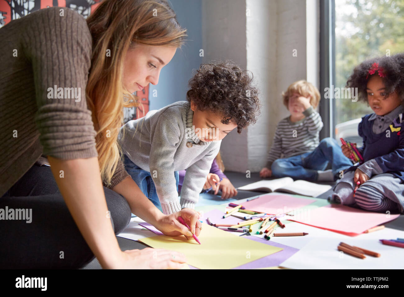 Professore di Disegno con gli studenti sul pianale in età prescolare Foto Stock