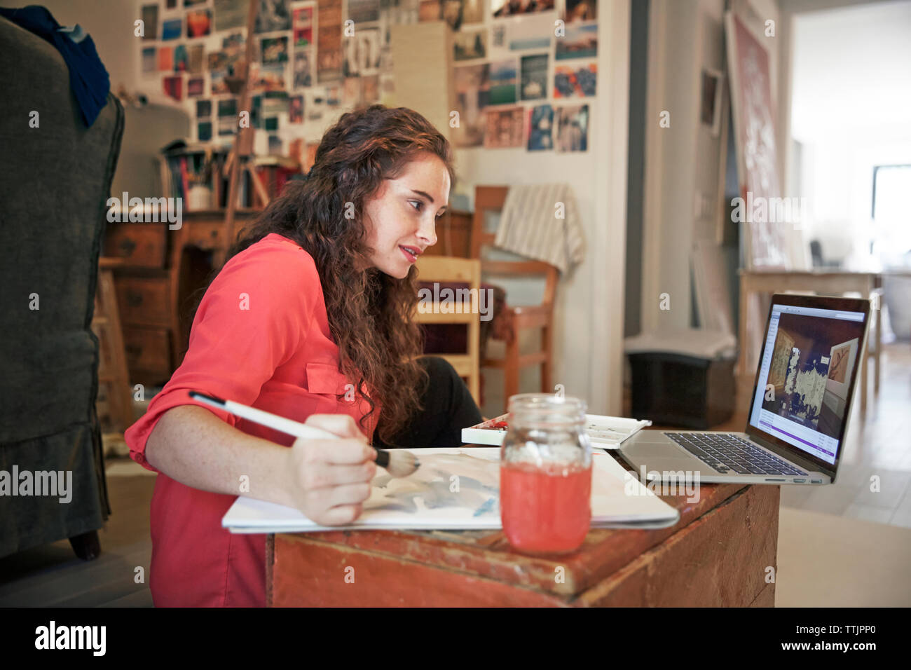 Fiducioso lavora una donna mentre guarda il computer portatile in ufficio Foto Stock