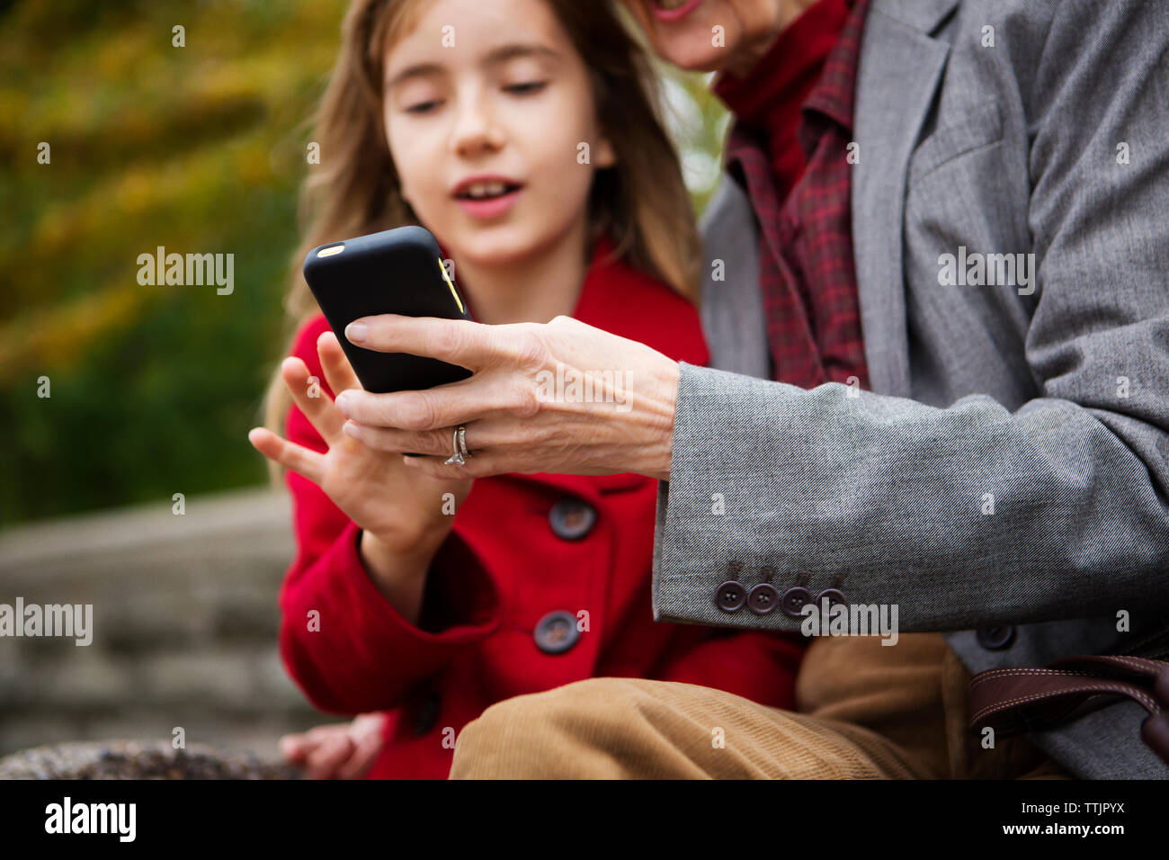 La famiglia tramite telefono cellulare mentre è seduto in posizione di parcheggio Foto Stock