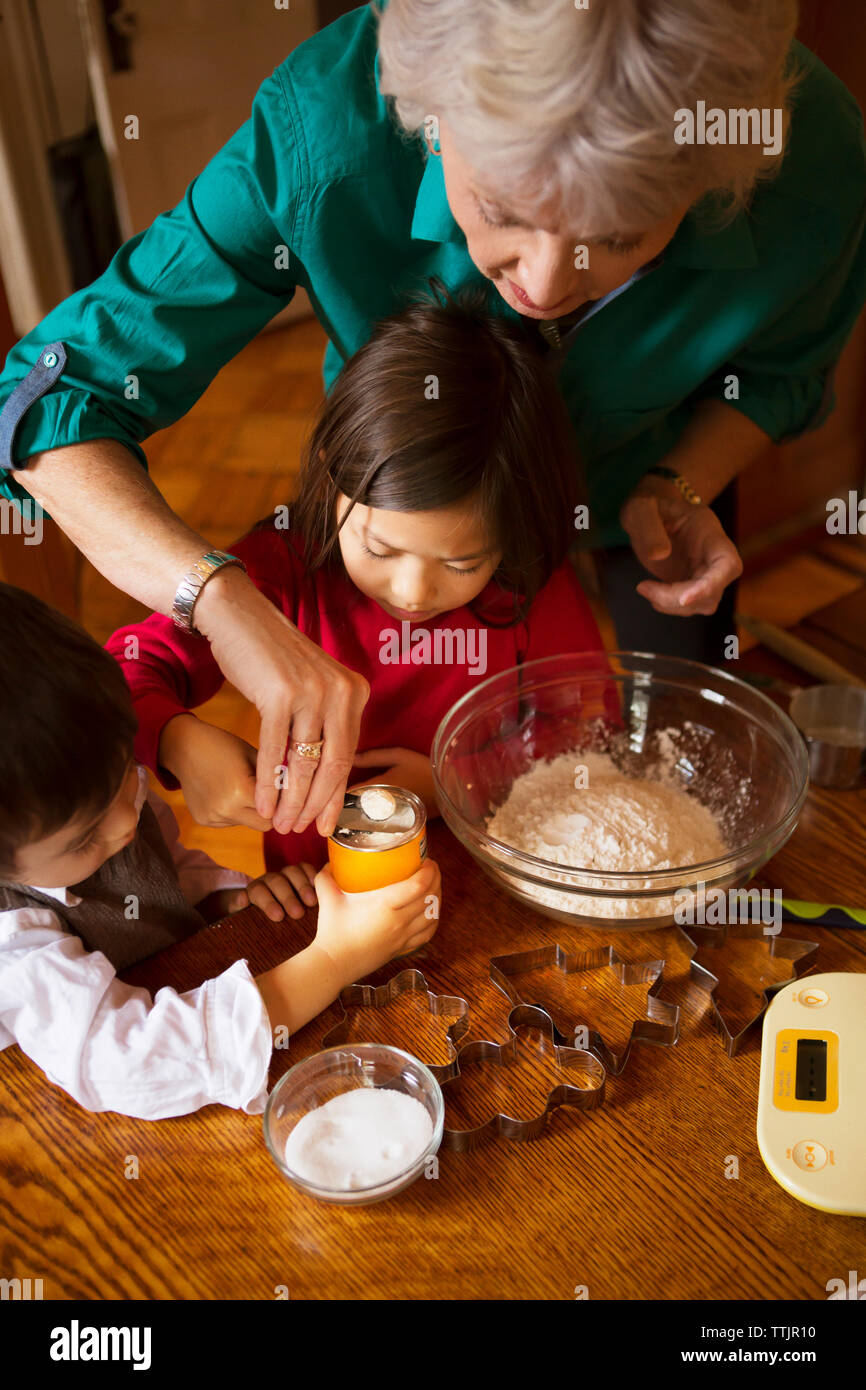 Angolo di Alta Vista della nonna con i bambini a preparare i biscotti alla home Foto Stock