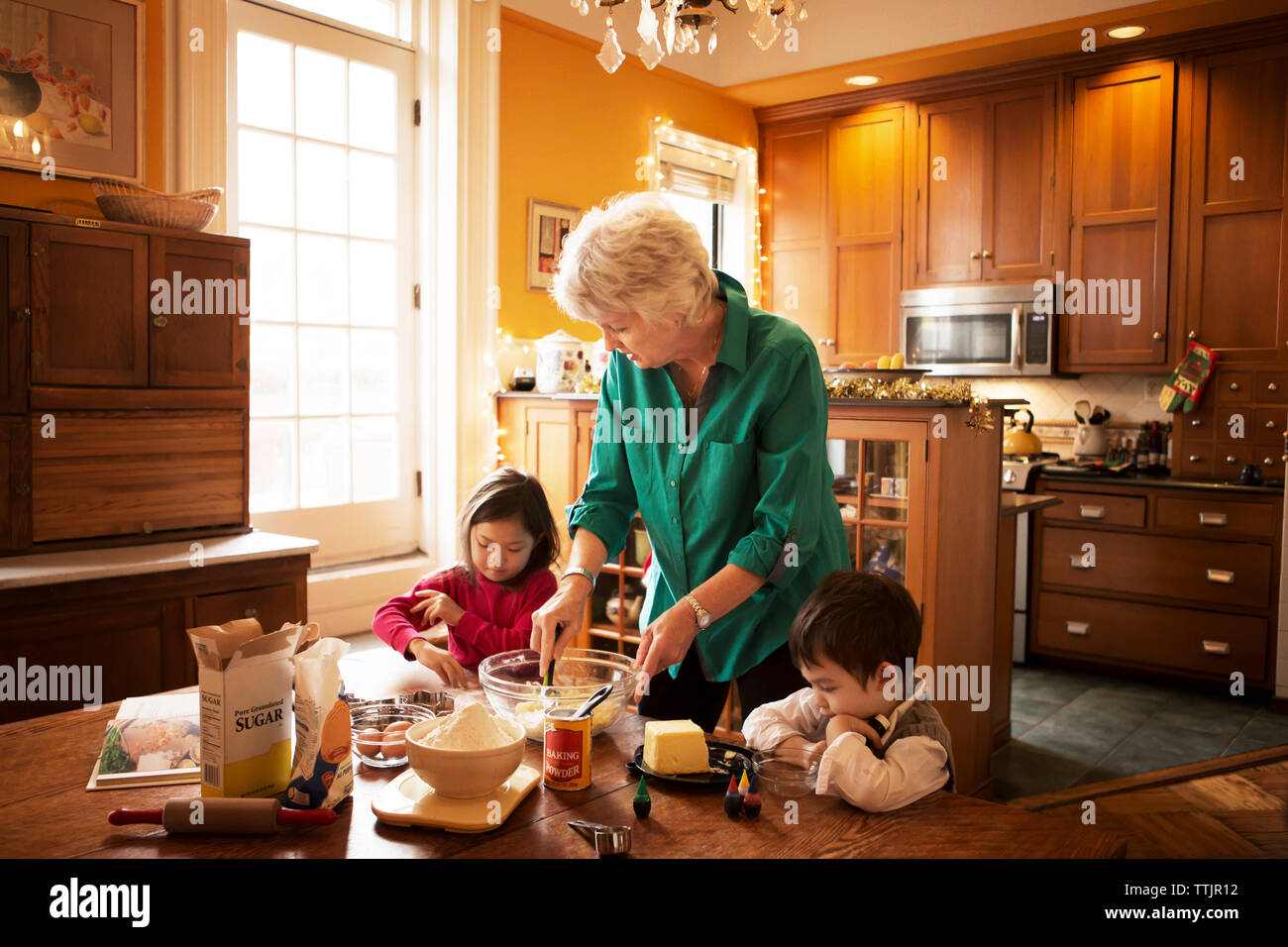 Nonna con i bambini che preparano i biscotti a casa durante il natale Foto Stock