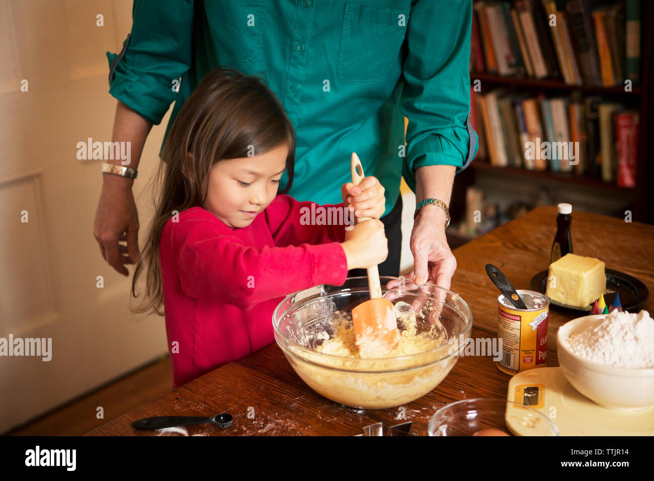 Midsection di nonna con ragazza che prepara biscotti a casa durante il natale Foto Stock
