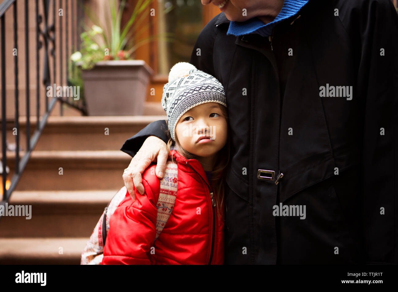 Sezione mediana della nonna con ragazza in piedi sui gradini Foto Stock