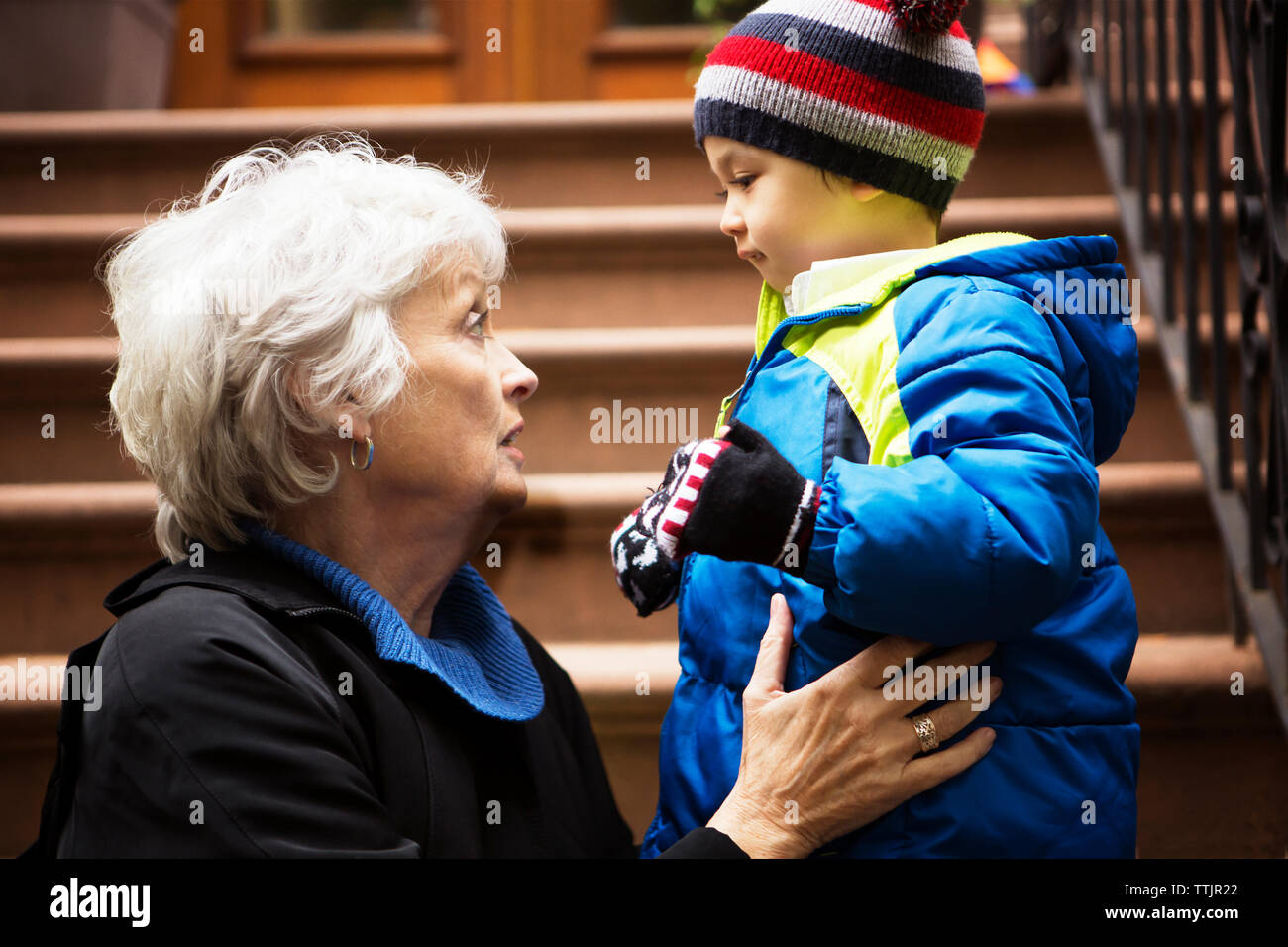 Nonna parlando con il ragazzo seduto su fasi Foto Stock