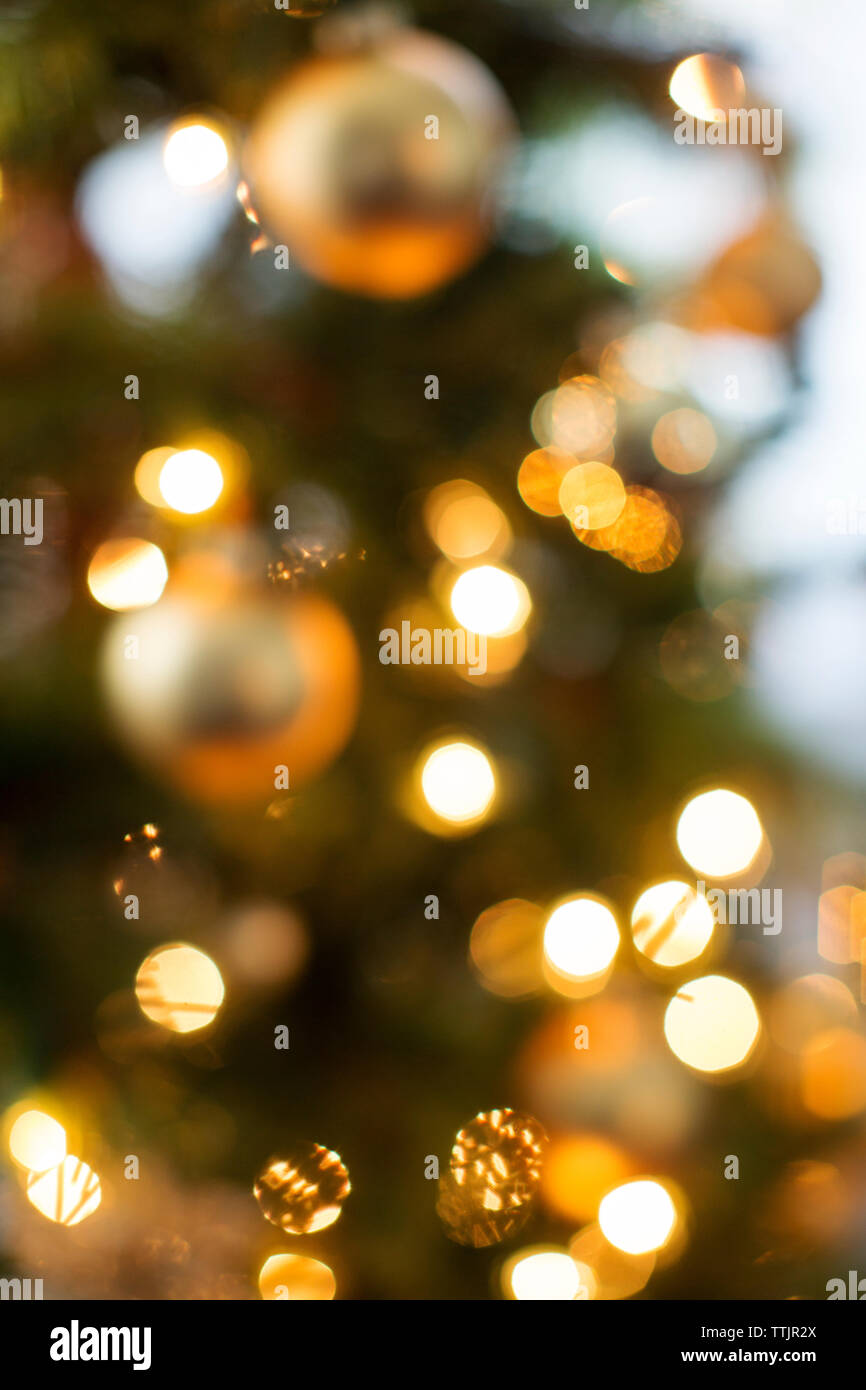 Immagine sfocata degli ornamenti sull'albero di natale illuminato Foto Stock