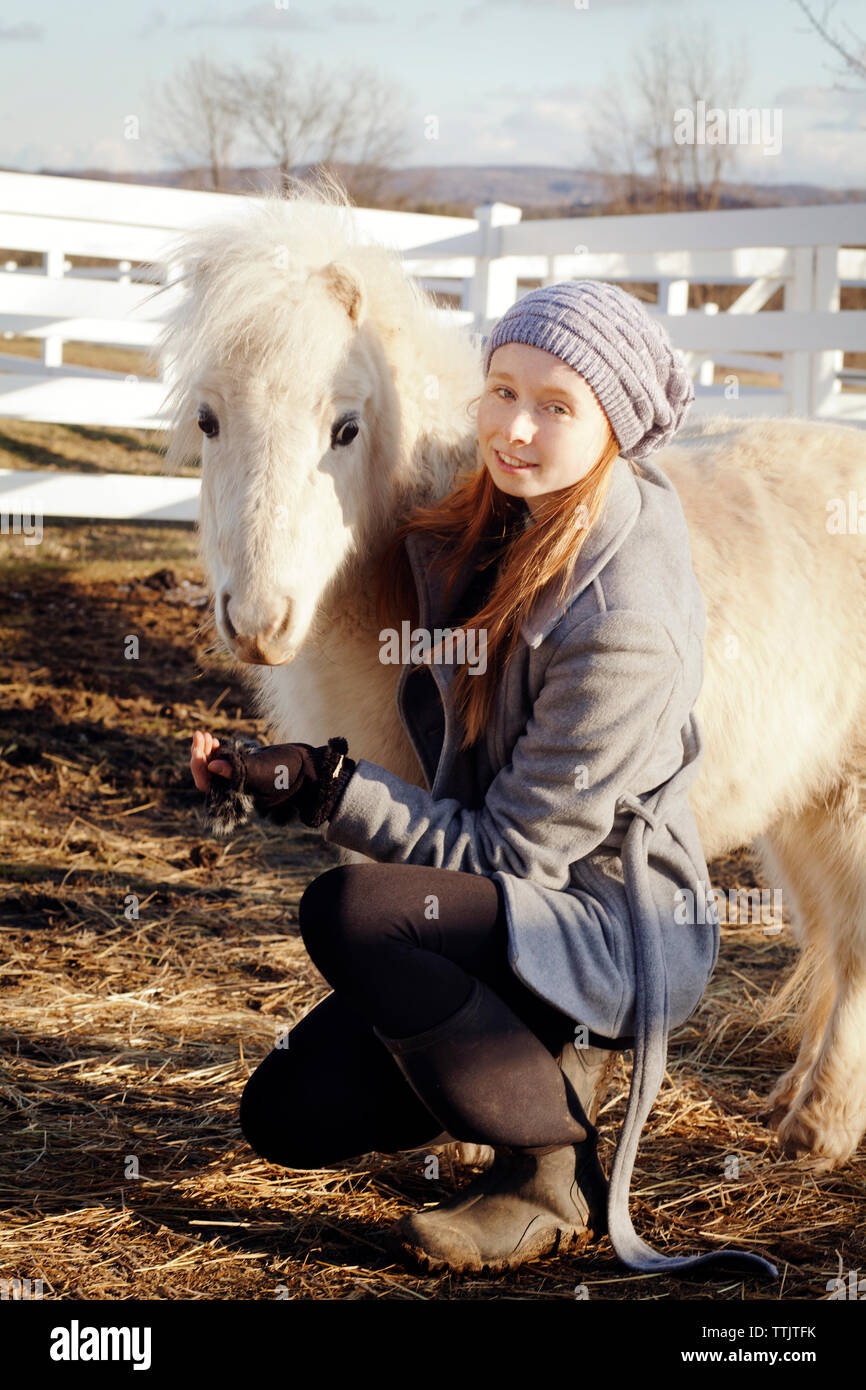 Ritratto di ragazza adolescente con pony bianco sul campo Foto Stock