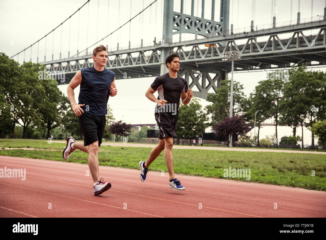 Amici in esecuzione su sport via contro Triborough Bridge Foto Stock