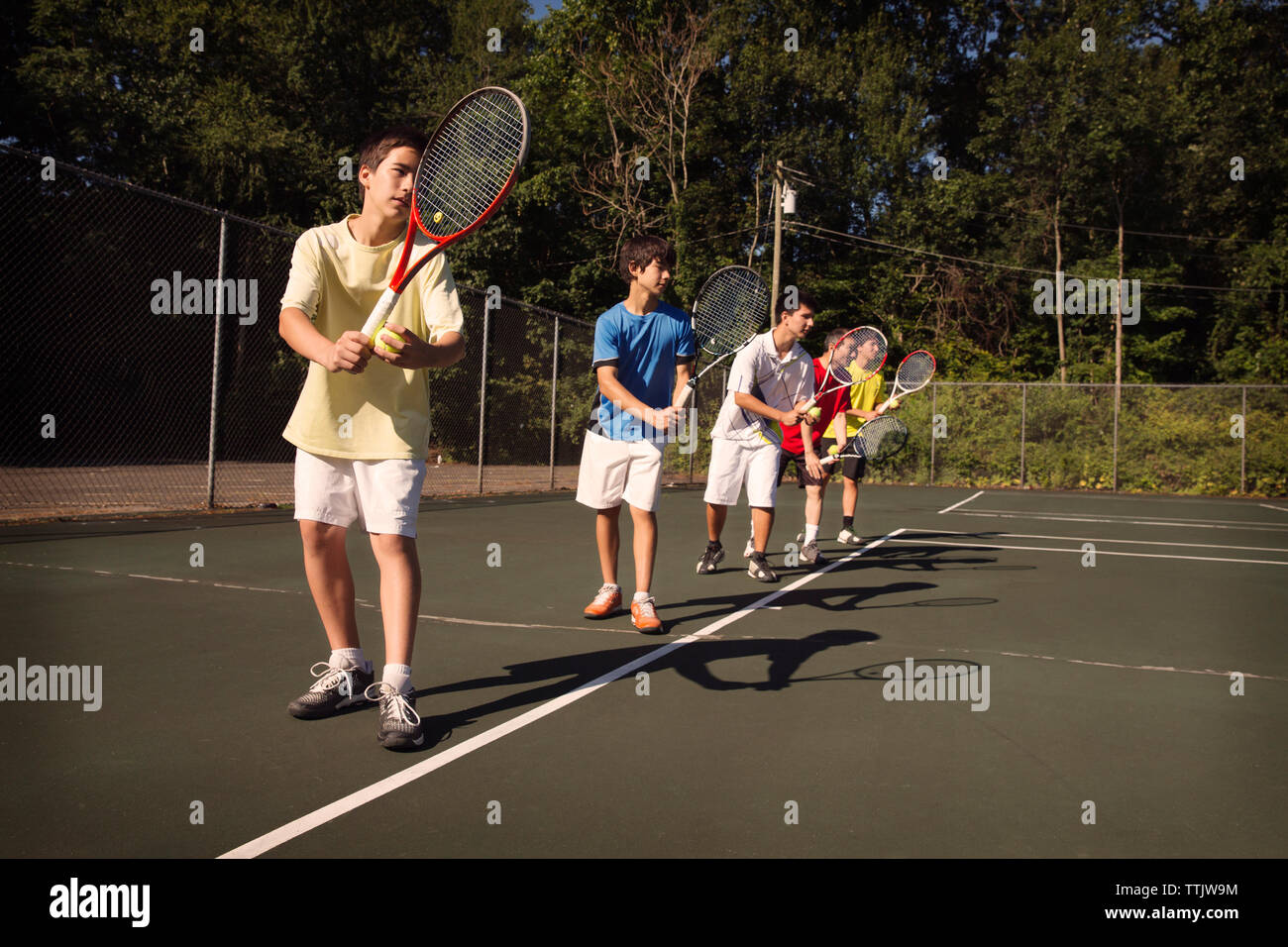 I giocatori in piedi in fila giocando a tennis a corte Foto Stock