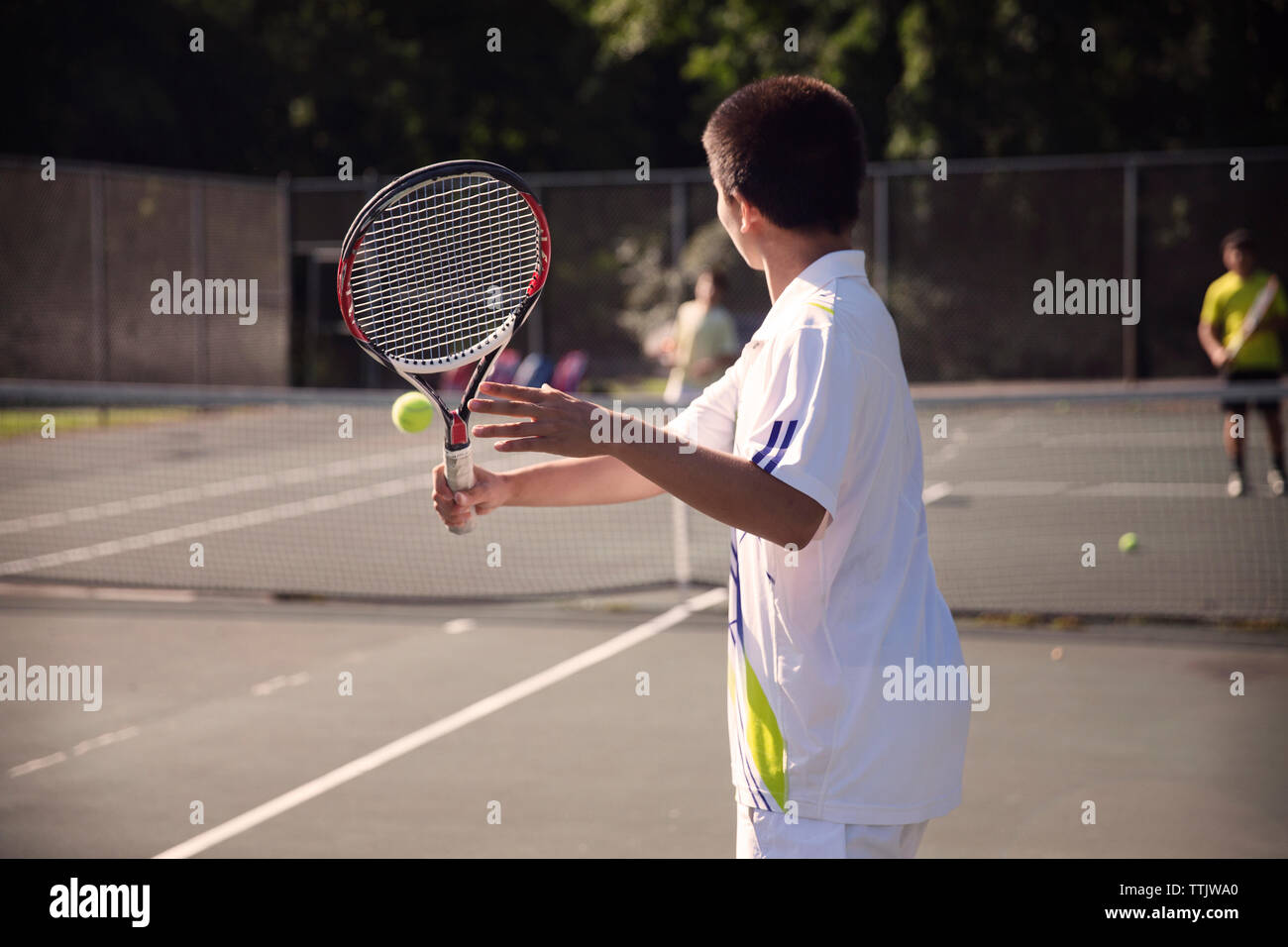 I giocatori che giocano di tennis alla Corte contro la recinzione Foto Stock