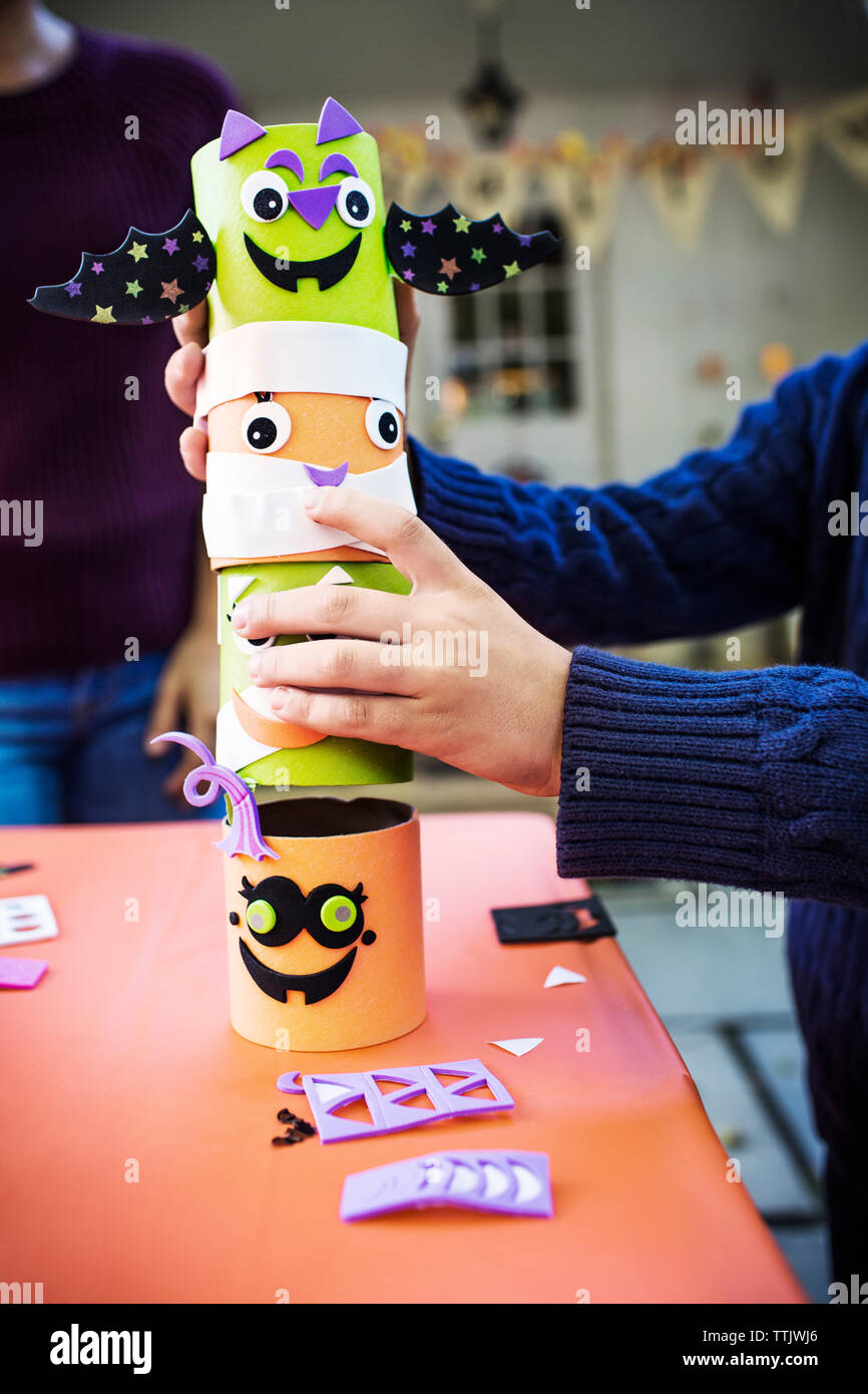 Immagine ritagliata di boy decorazione di impilamento al tavolo durante la festa di Halloween Foto Stock