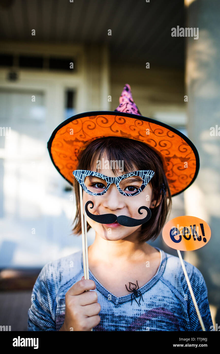 Ritratto di sorridente ragazza con puntelli godendo durante la festa di Halloween Foto Stock