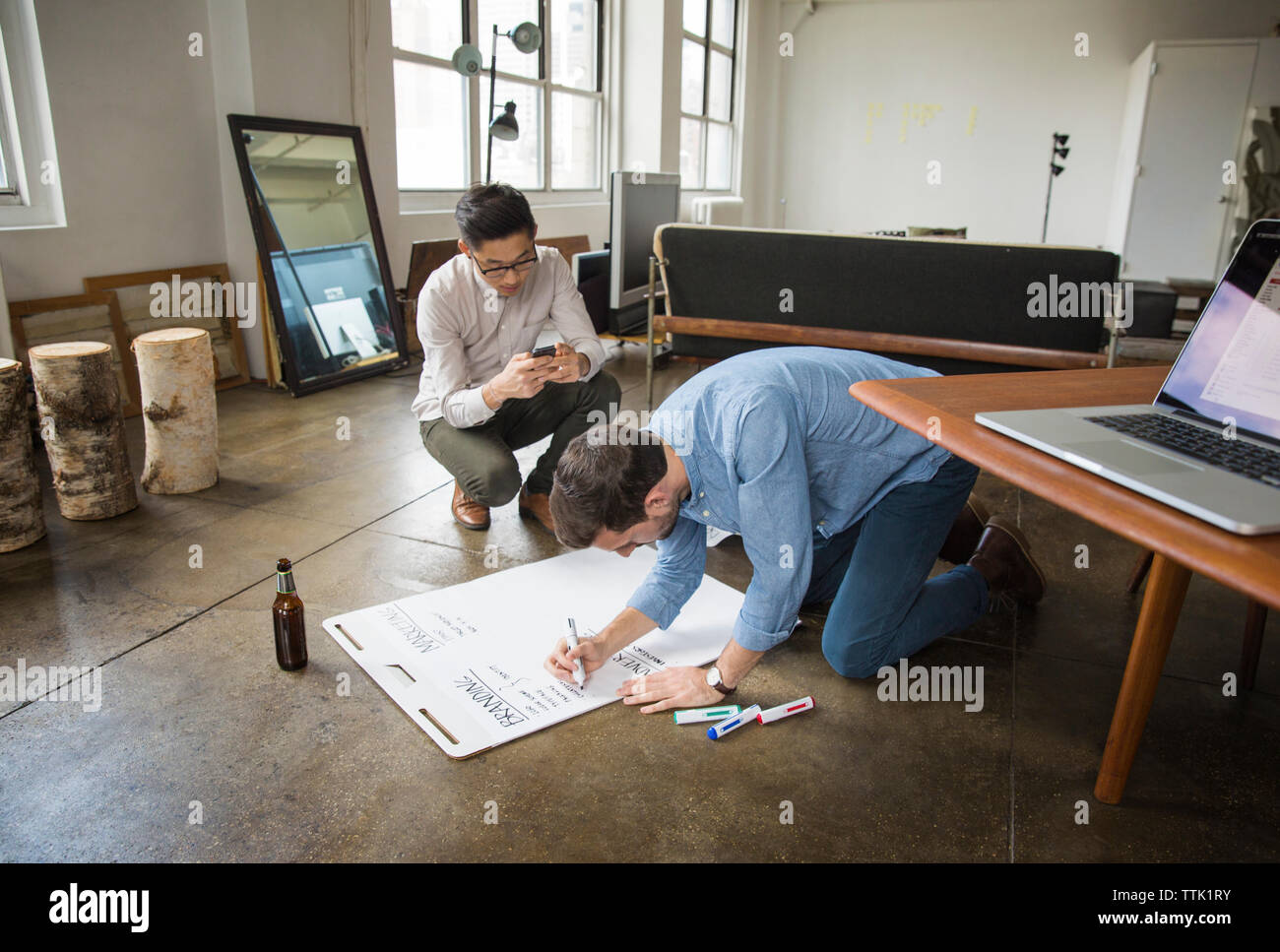 uomini d'affari che scrivono su lavagna bianca nell'ufficio creativo Foto Stock