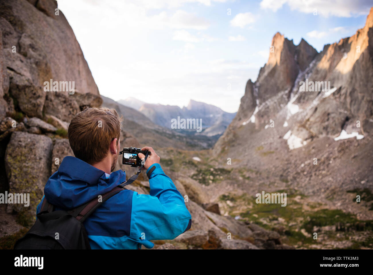 Escursionista fotografare mentre in piedi sulle rocce Foto Stock