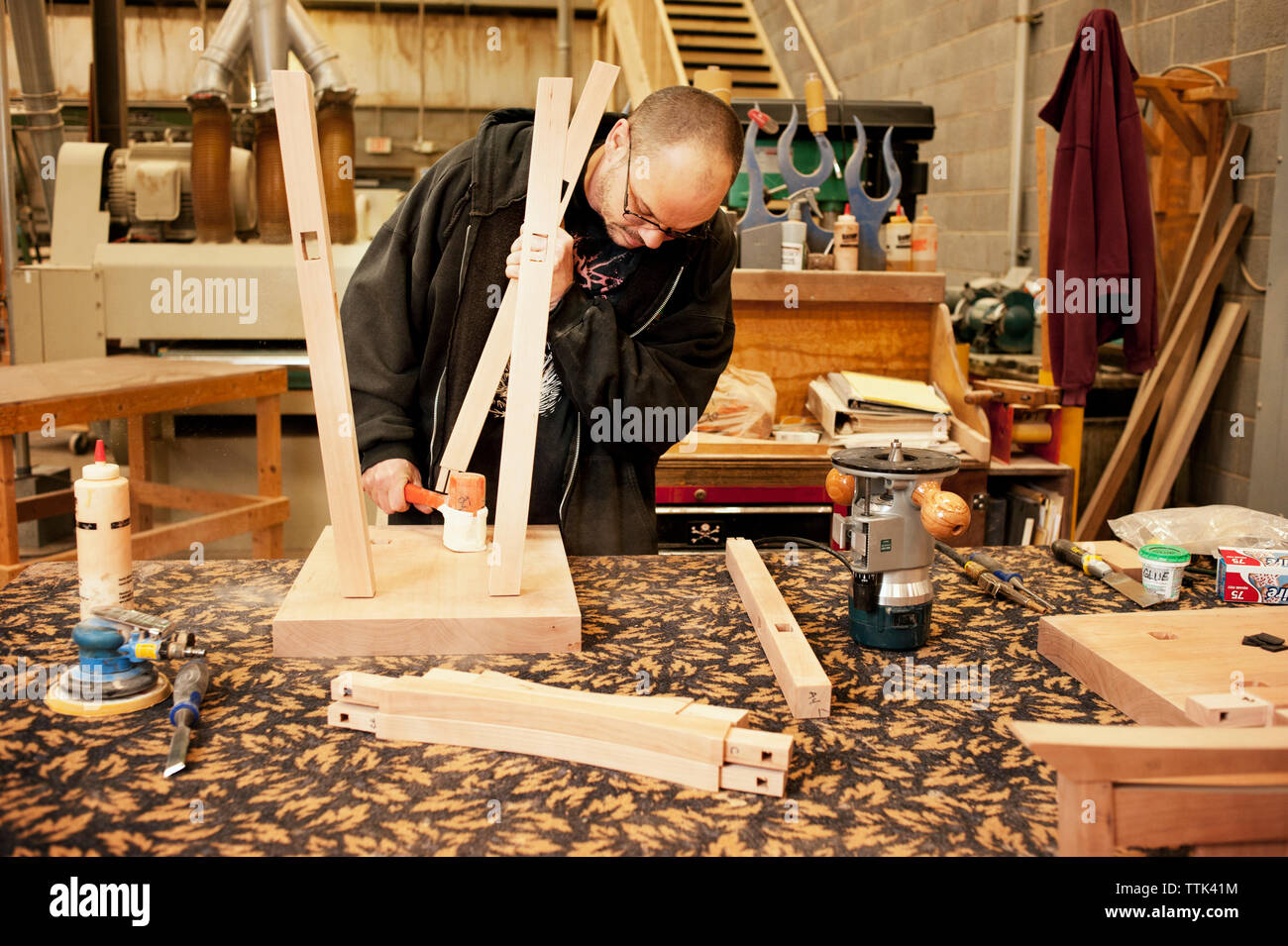 Lavoratore manuale facendo uno sgabello in officina Foto Stock