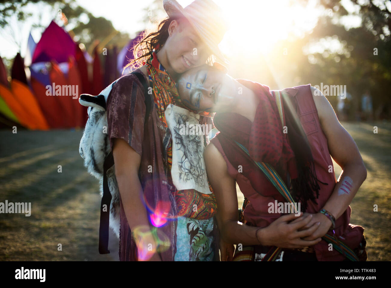 Sorridente amici abbracciando mentre permanente al tradizionale evento Foto Stock