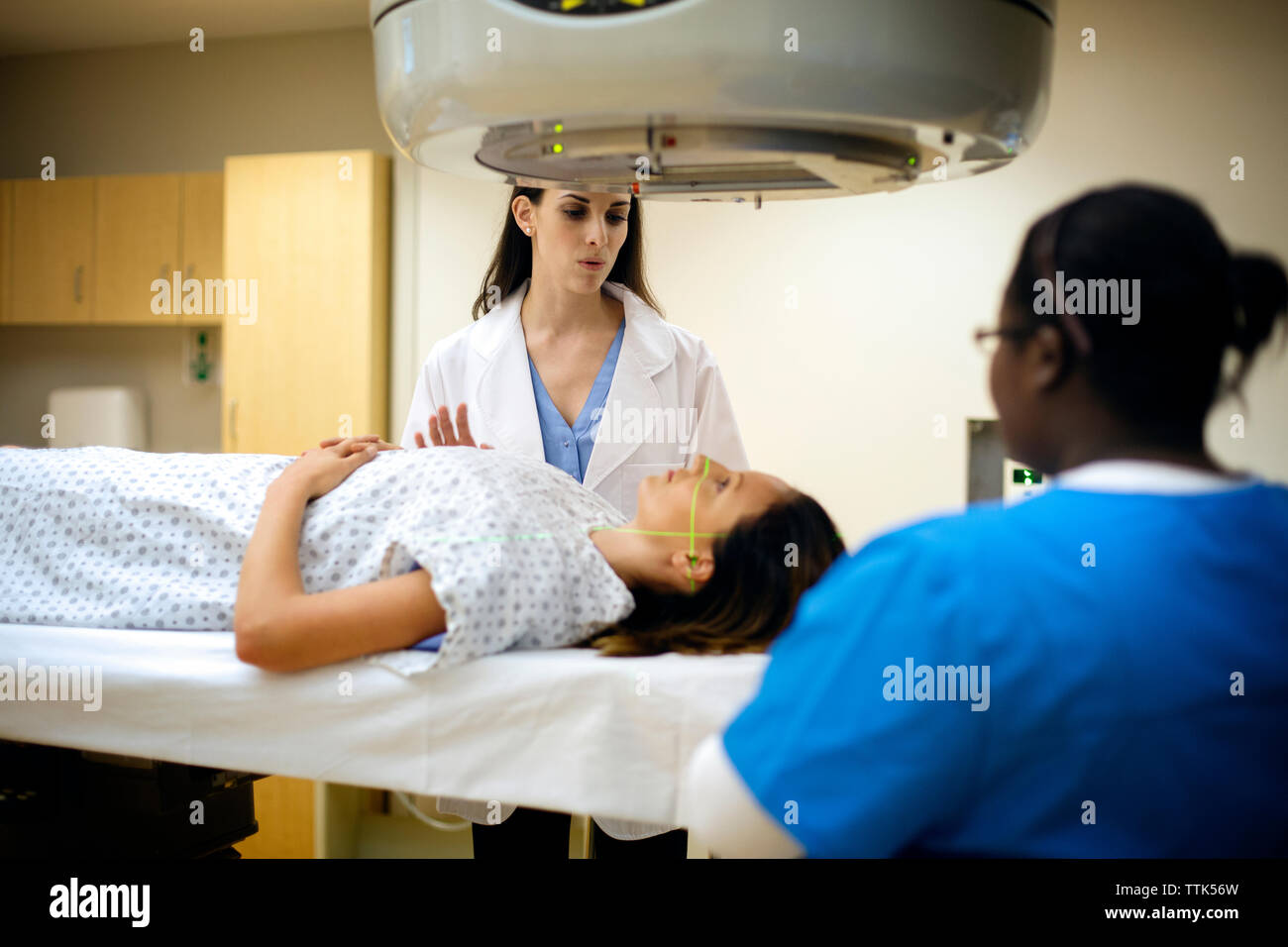 Medico e infermiere guardando il paziente disteso sul lettino Foto Stock