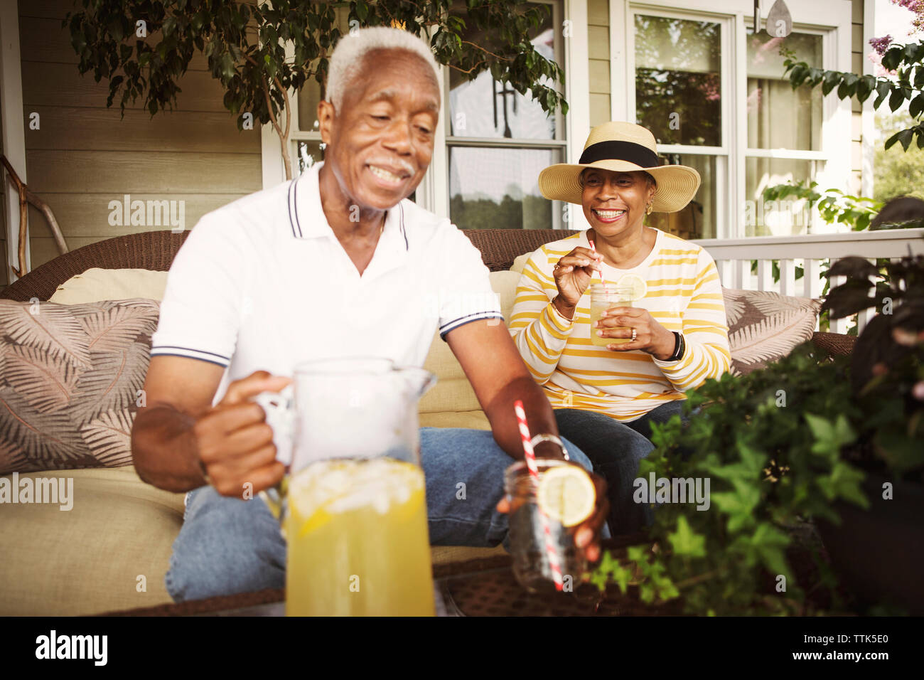 Felice coppia senior di bere la limonata seduti sulla veranda Foto Stock