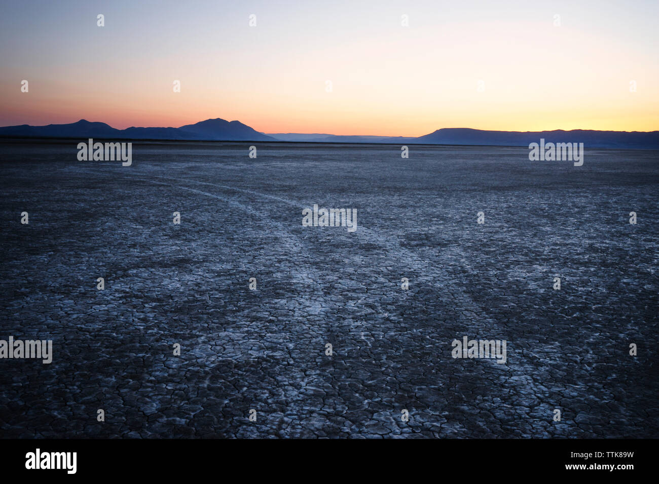 Vista panoramica del campo e le montagne contro il cielo durante il tramonto nel deserto Alvord Foto Stock