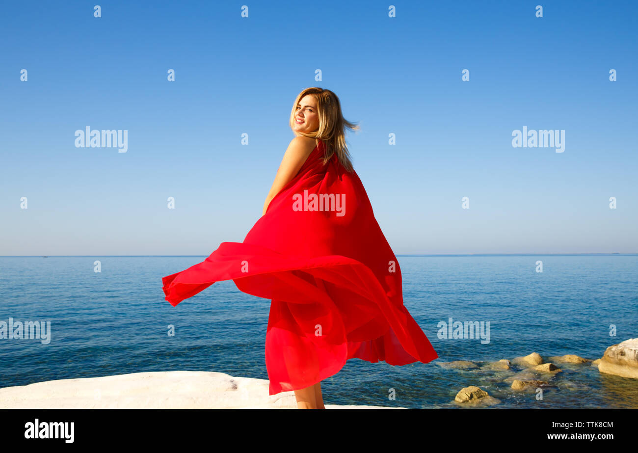 La donna in abito rosso presso la spiaggia di Cipro. Foto Stock