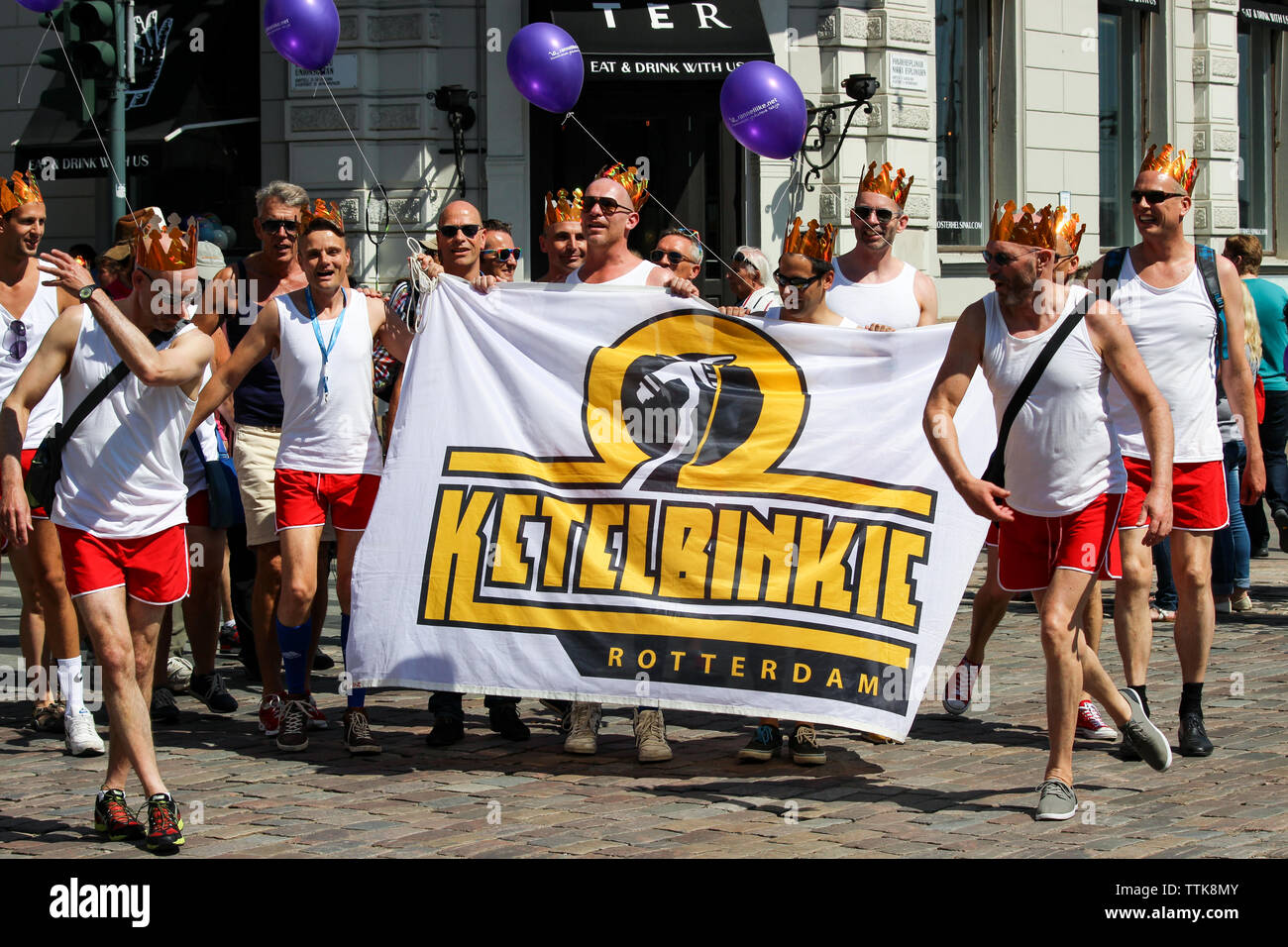 Uomini che indossano corone di cartone che detengono il banner del club sportivo LGBT Ketelbinkie Rotterdam all'Helsinki Pride Parade 2016 di Helsinki, Finlandia Foto Stock